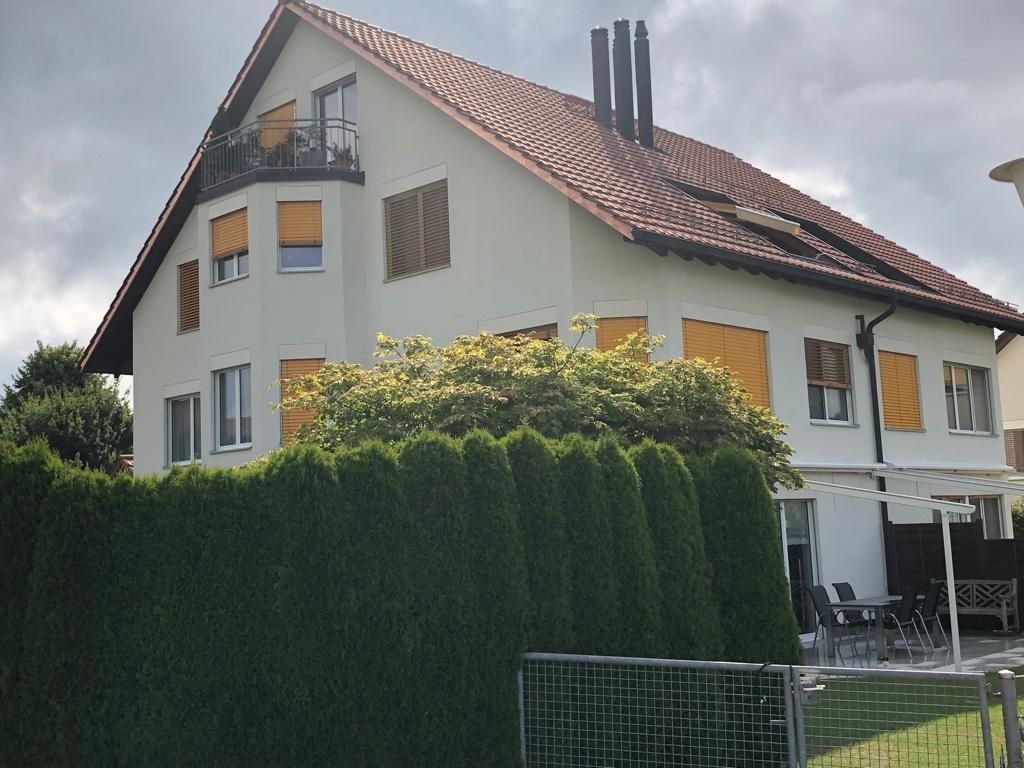 Ein grosses weisses Haus mit einem roten Ziegeldach