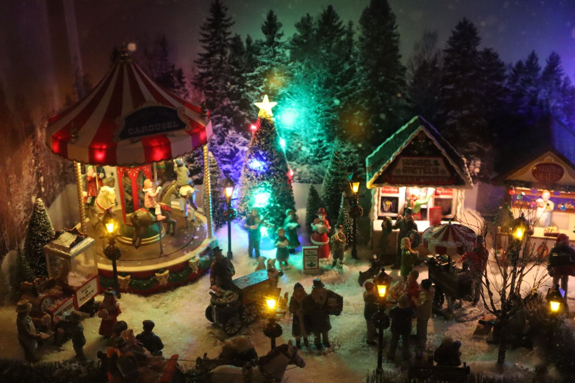Eine Weihnachtsszene mit einem Karussell und einem Weihnachtsbaum.