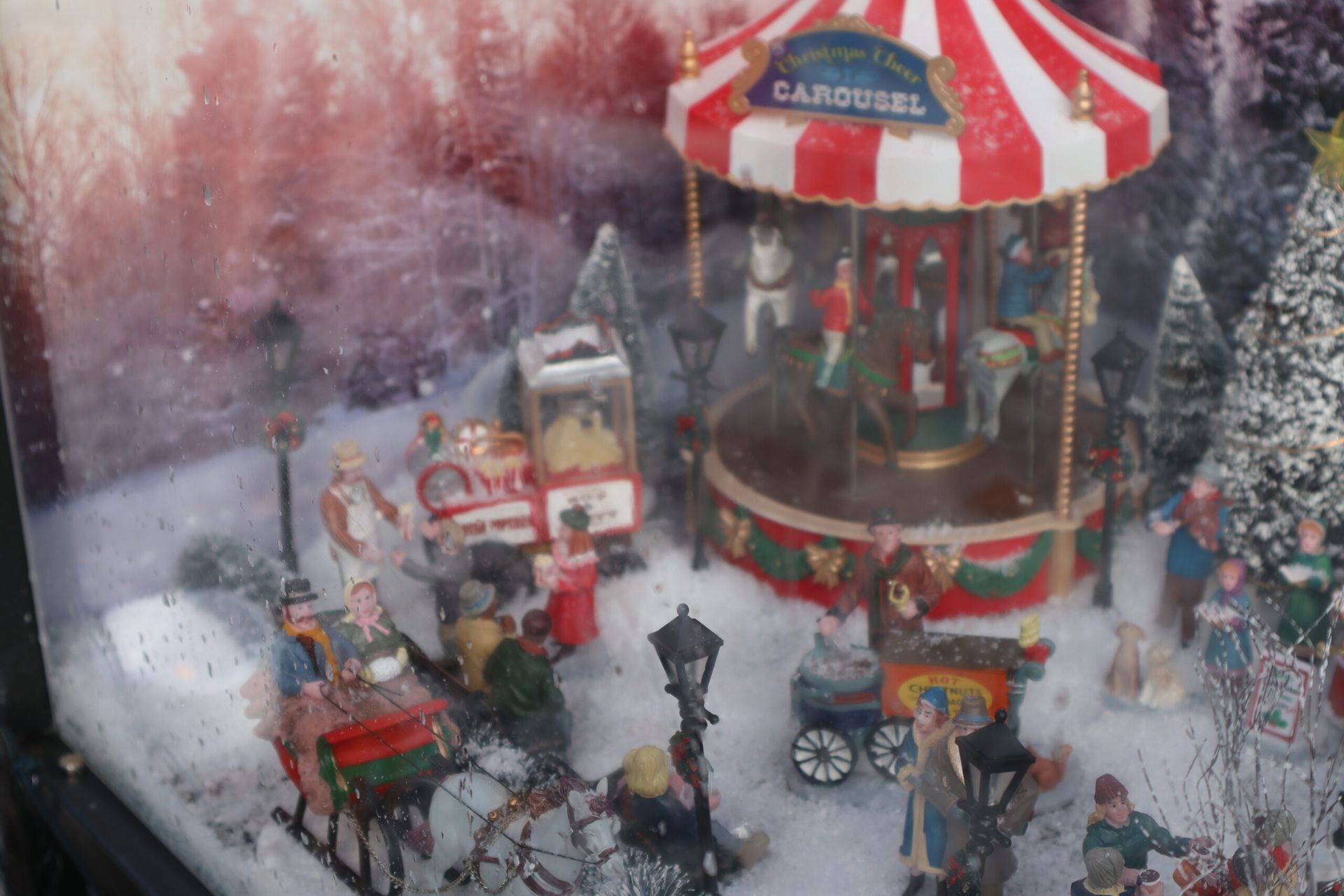Eine Weihnachtsszene mit einem Karussell im Schnee.