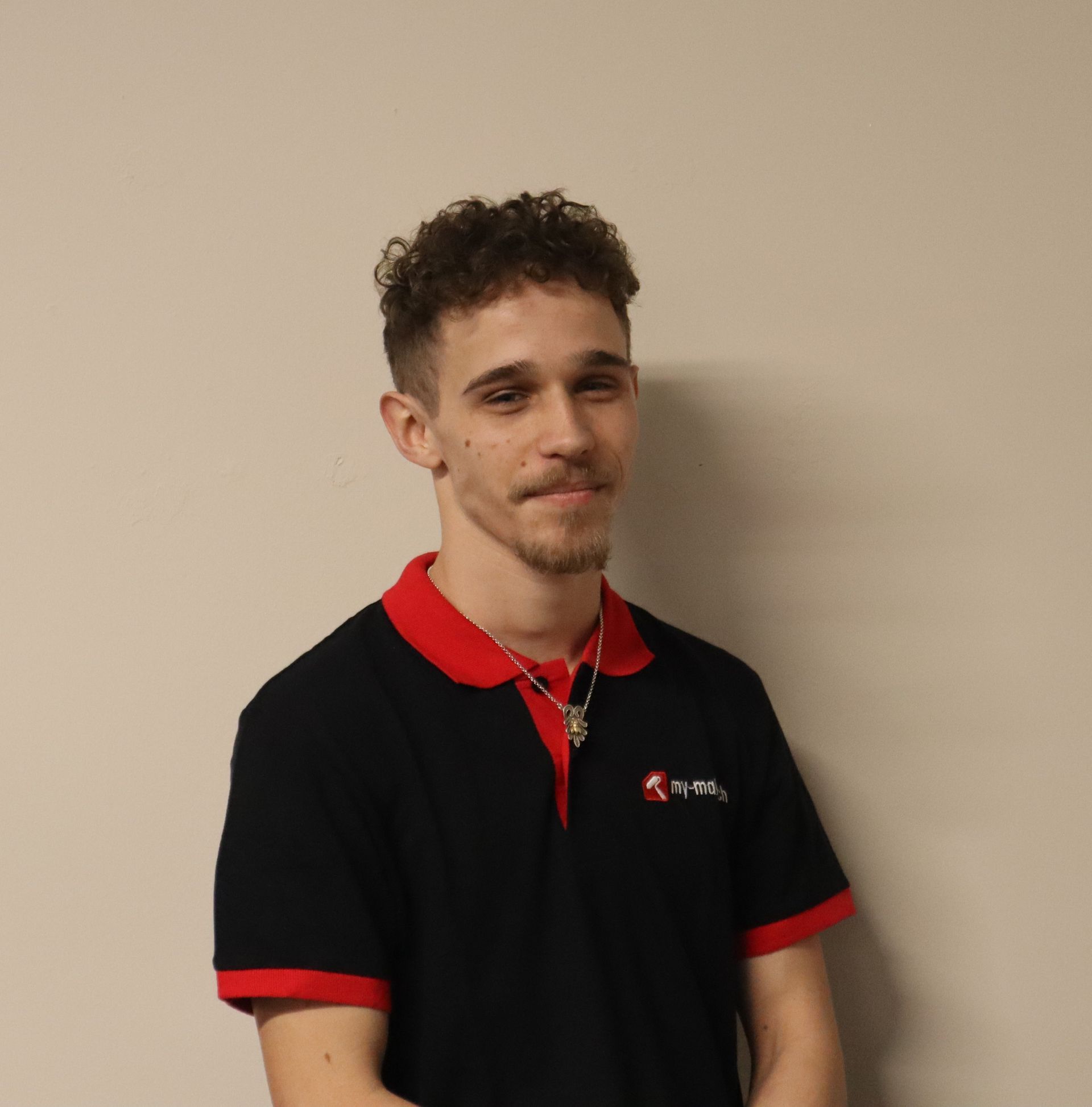 Ein Mann trägt ein schwarzes Hemd mit rotem Kragen.