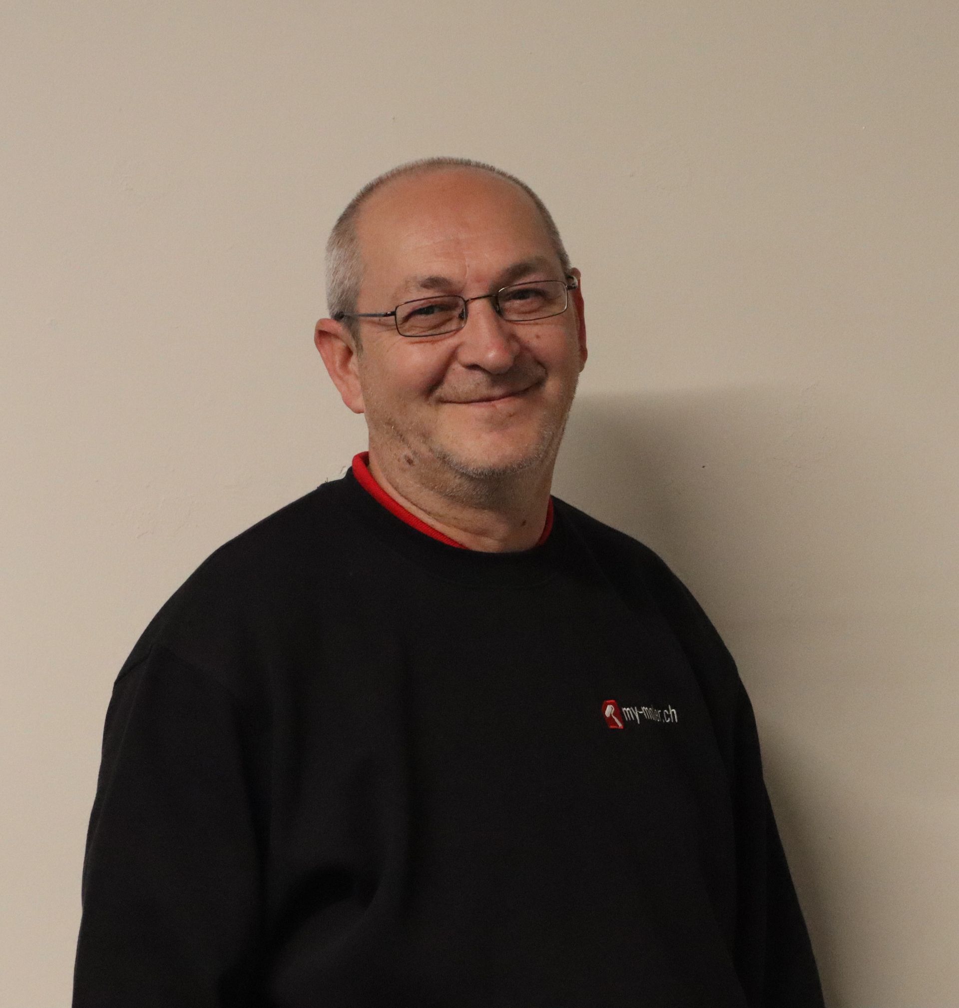 Ein Mann trägt eine schwarze Jacke.