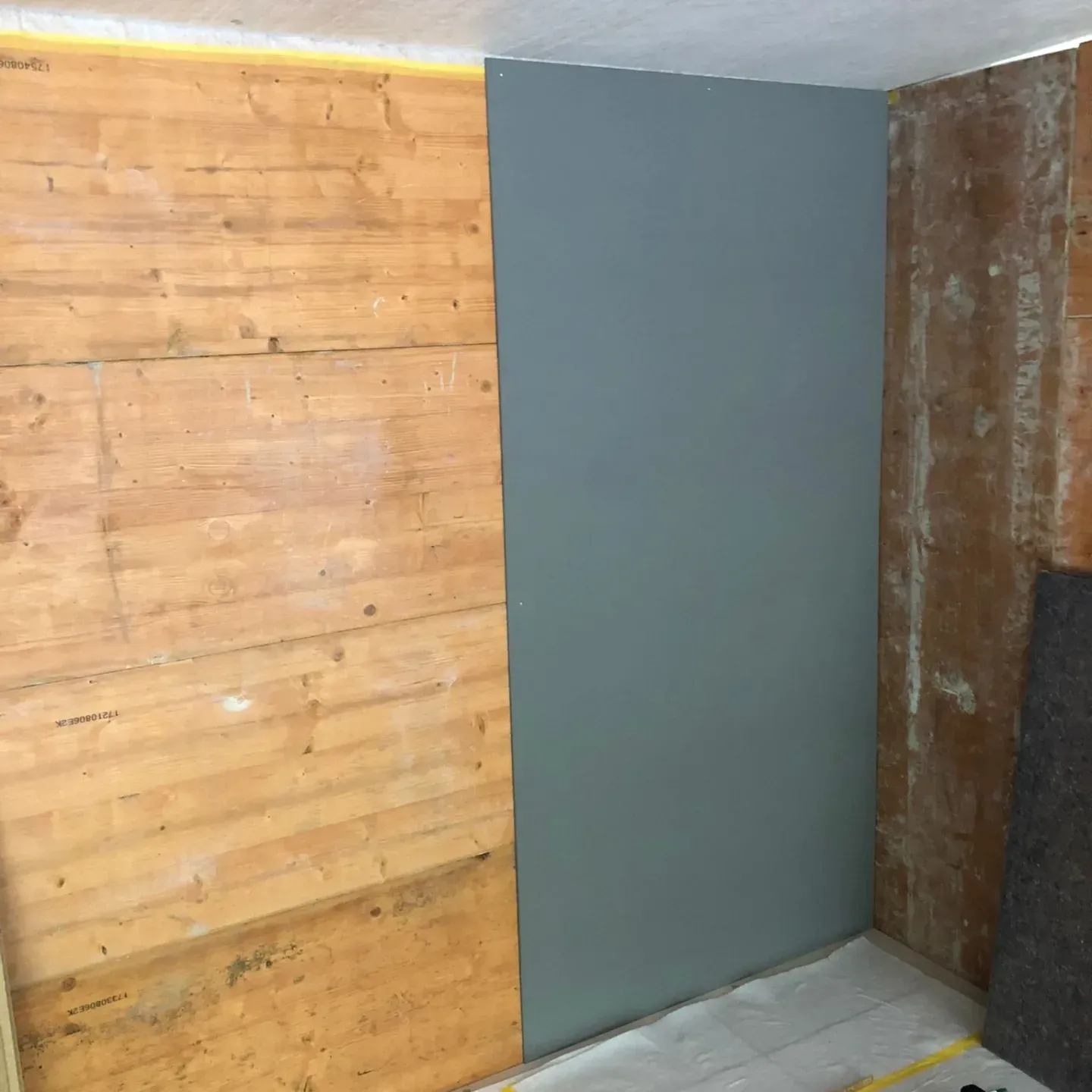 Ein Raum mit einer Holzwand und einer grau-blauen Wand