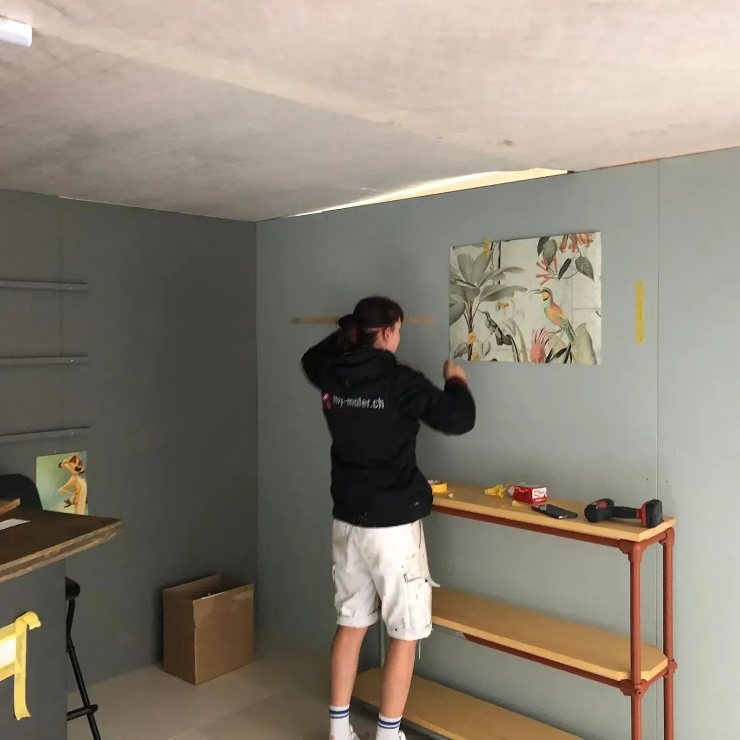 Ein Mann malt ein Bild an der Wand