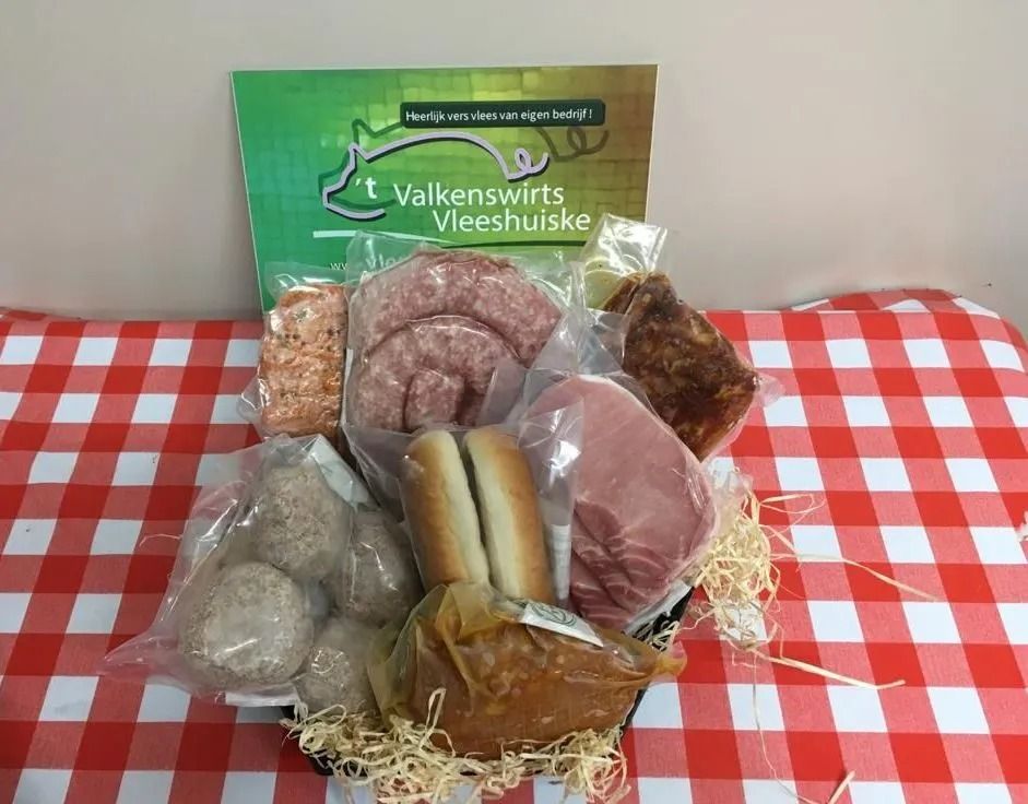 Vleesselectie in een mandje op een rood-wit geblokt tafelkleed.