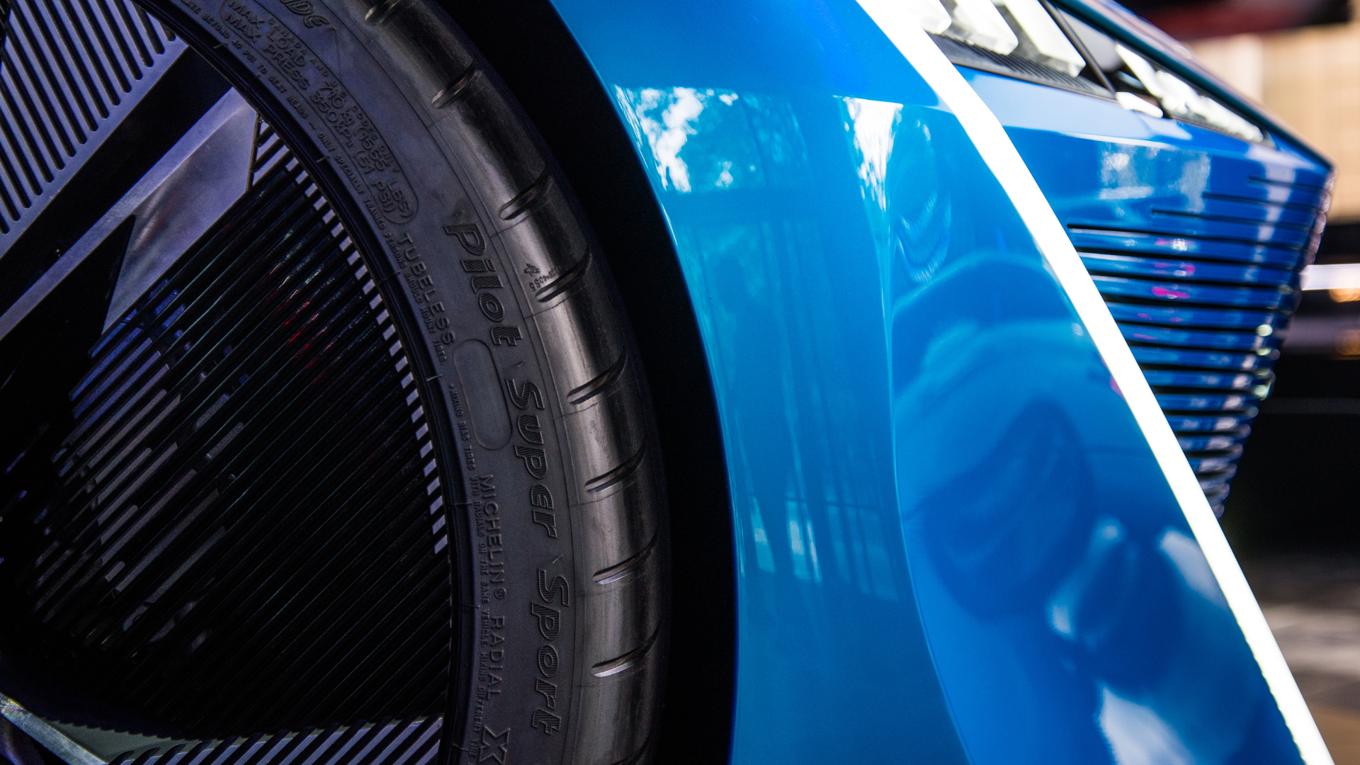 Blue car fender, tire, and wheel; close-up shot.