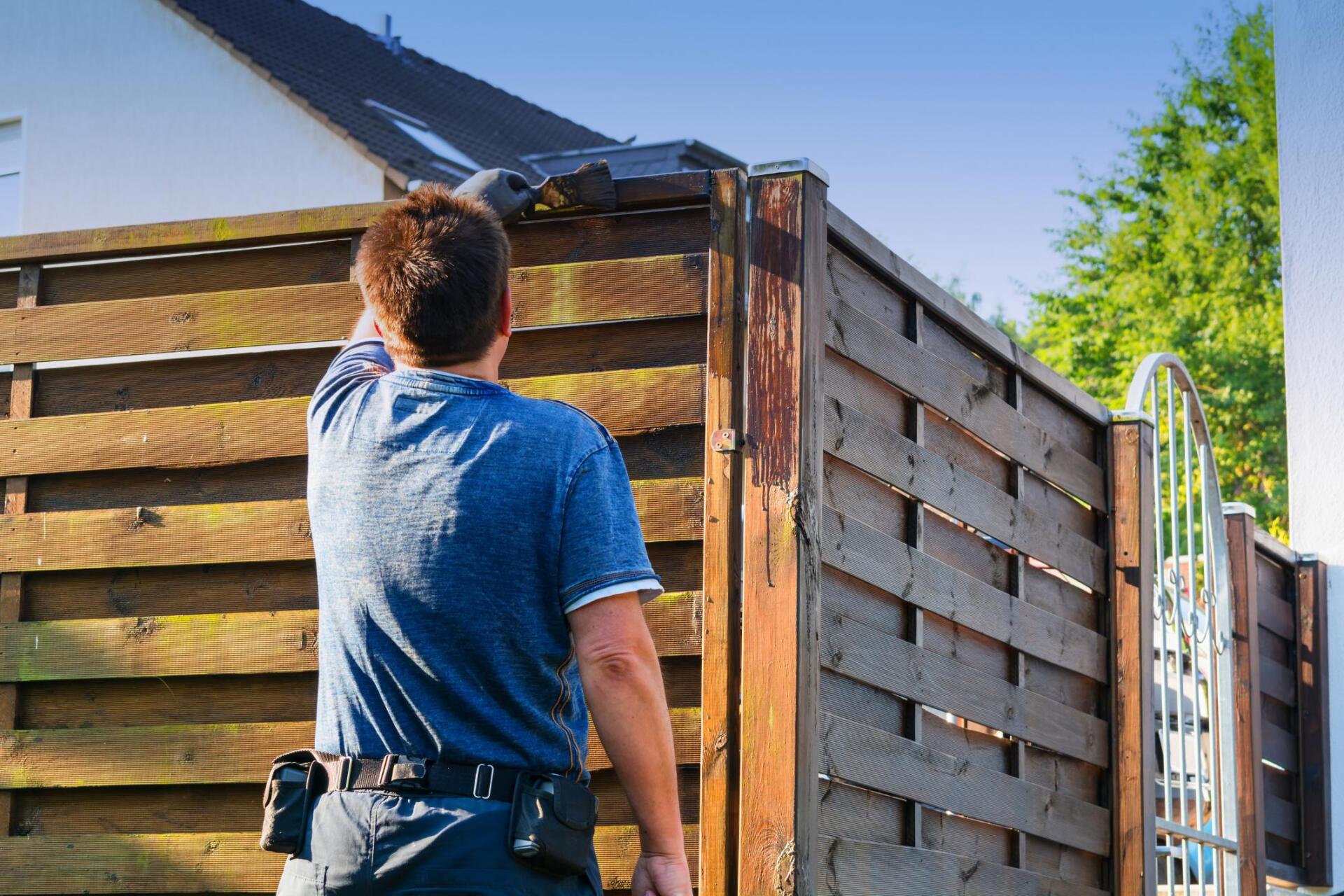 man painting the fence