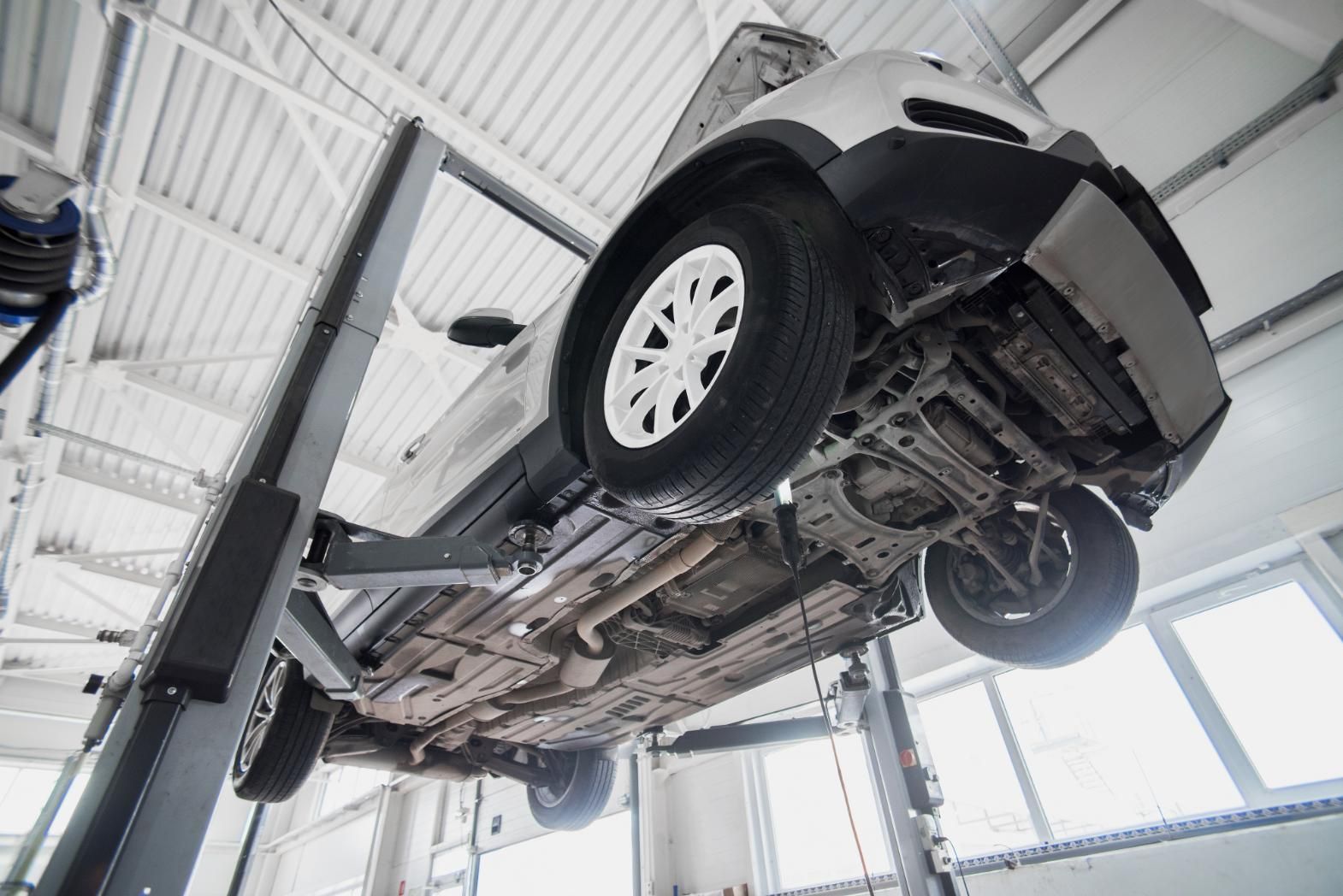 A Car Is Sitting On A Lift In A Garage — Advanced Windscreens & Service Centre In Airlie Beach, QLD