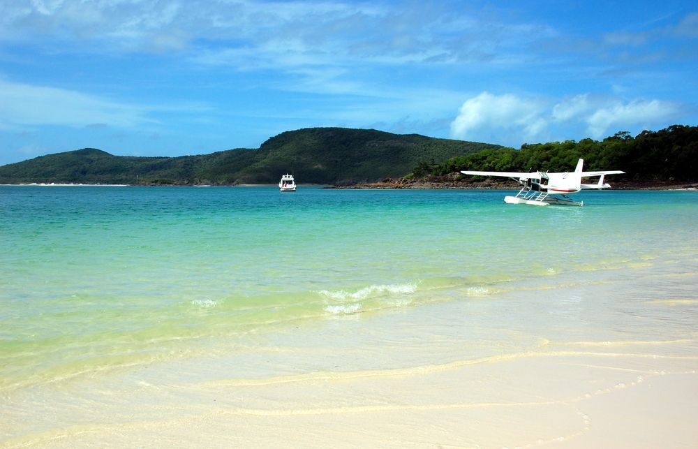A Seaplane Is Taking Off From A Beach In The Ocean — Advanced Windscreens & Service Centre In Airlie Beach, QLD