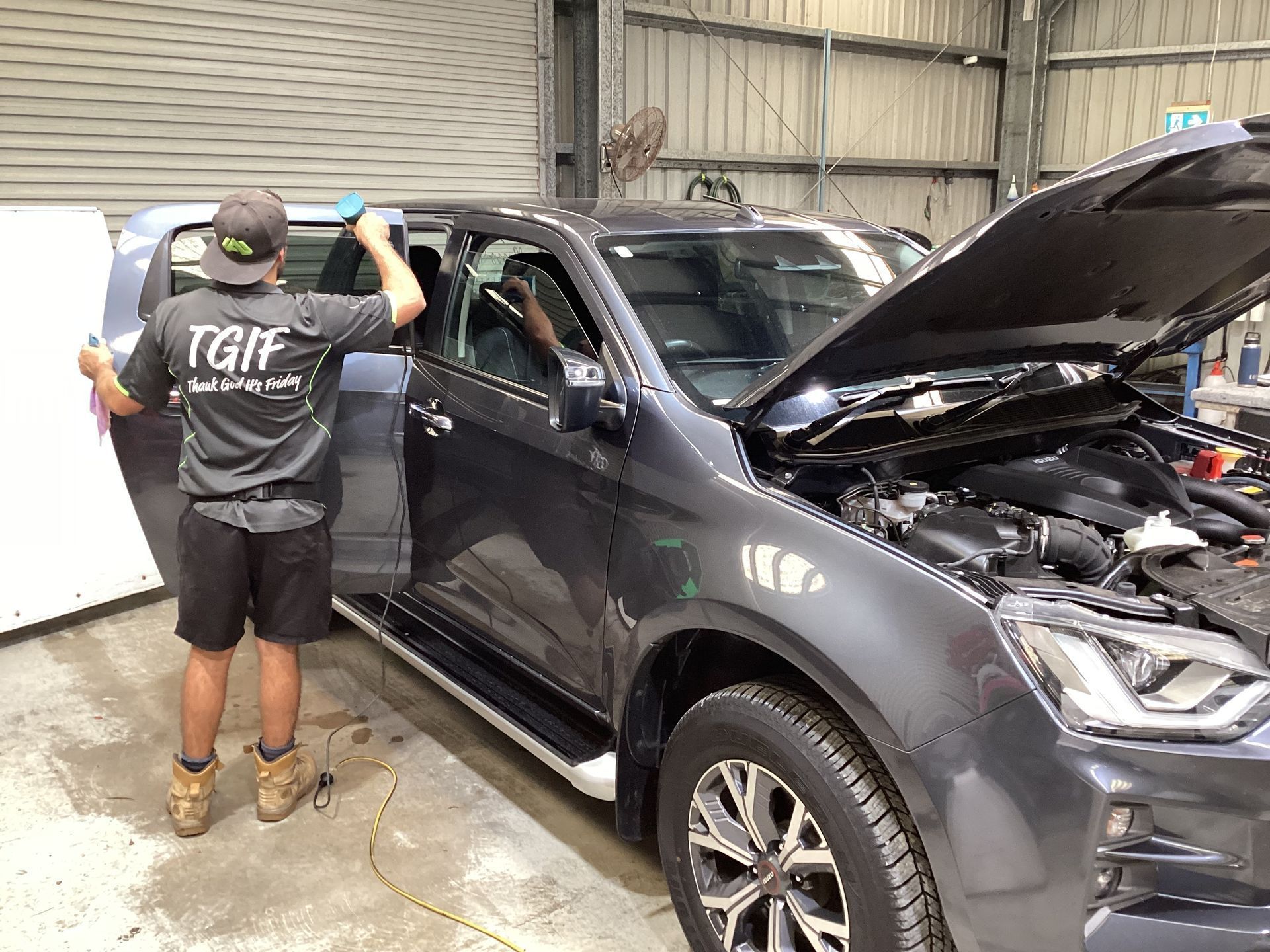 A Man Tinting A Window Of A Car — Advanced Windscreens & Service Centre In Proserpine, QLD