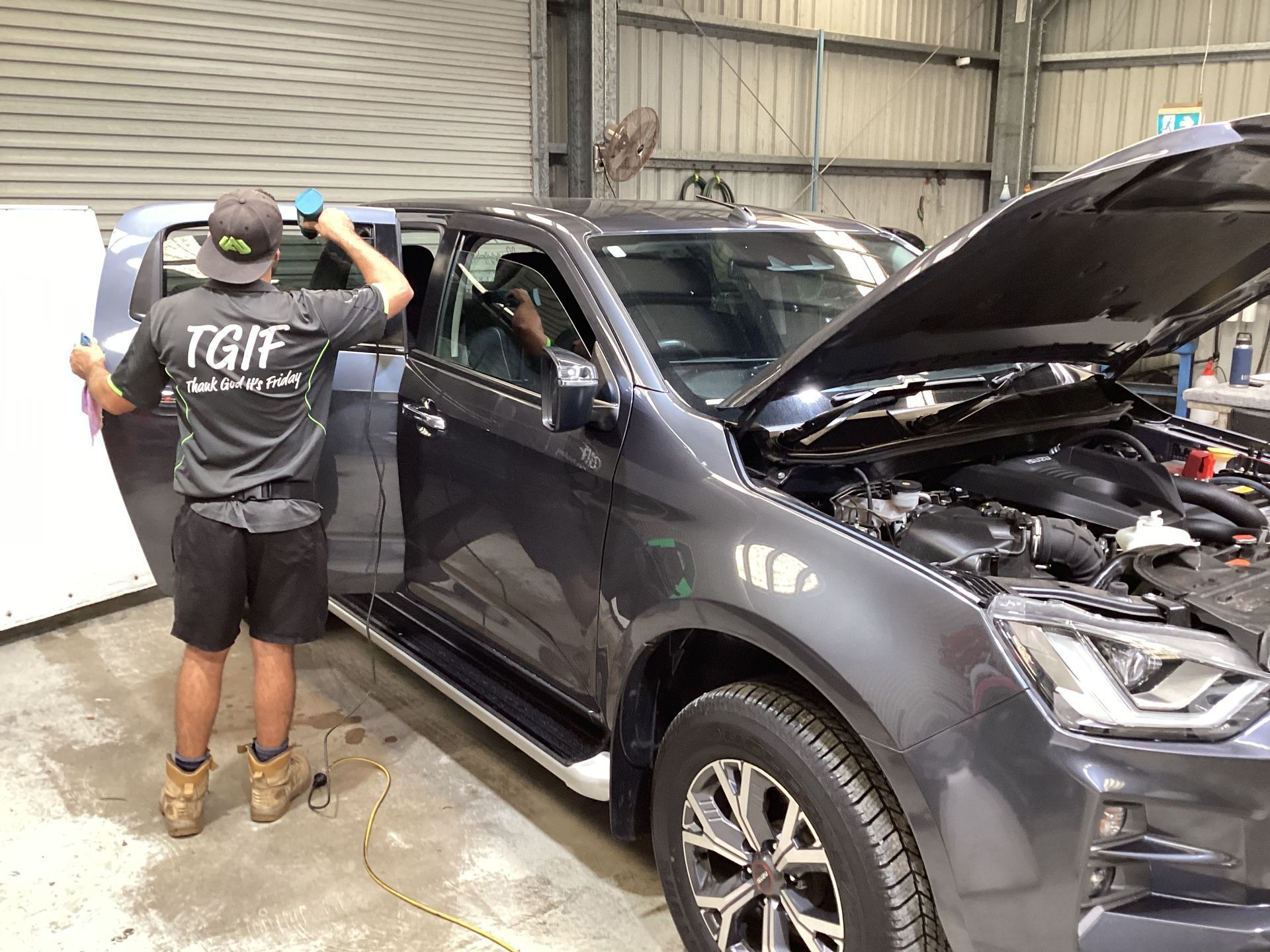A Person Is Tinting Glass On  A Car With A Heat Gun— Advanced Windscreens & Service Centre In Proserpine, QLD
