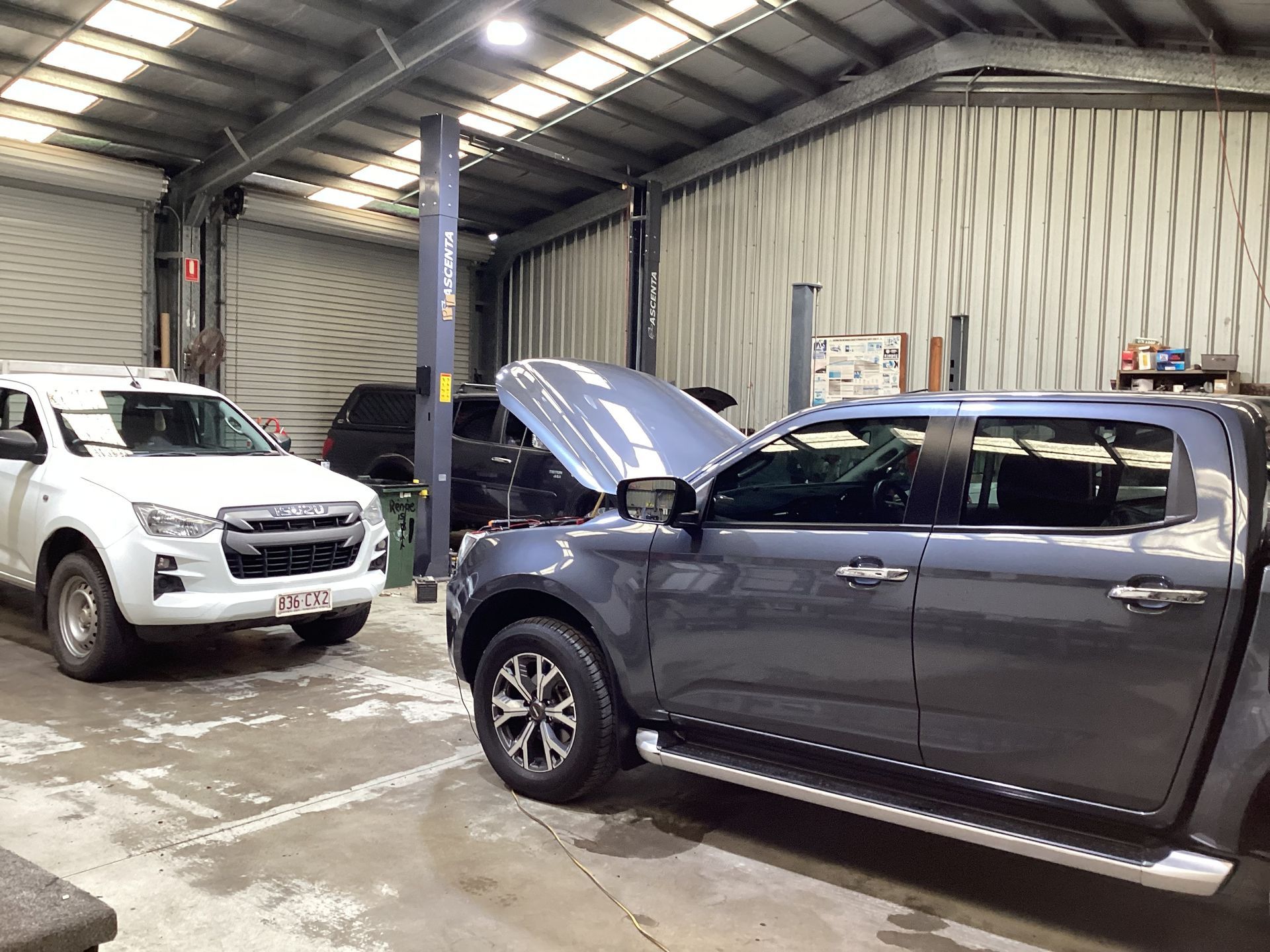 Two Cars In A Garage One Has Its Bonnet Up— Advanced Windscreens & Service Centre In Proserpine, QLD