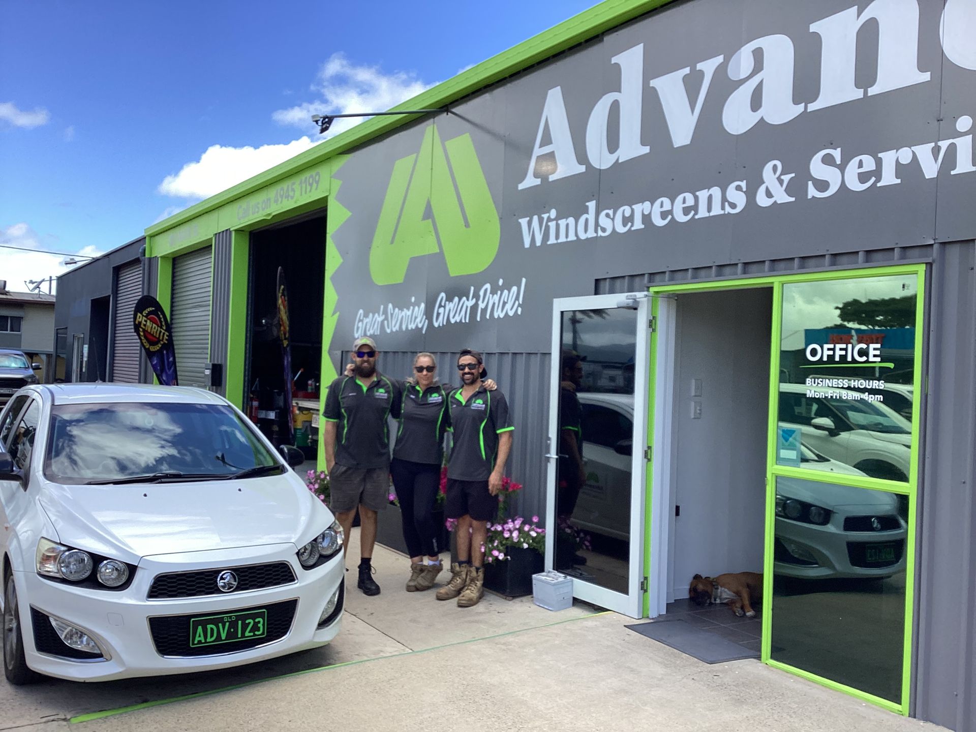 A group of people standing in front of a building with a car parked in front of it — Advanced Windscreens & Service Centre In Proserpine, QLD