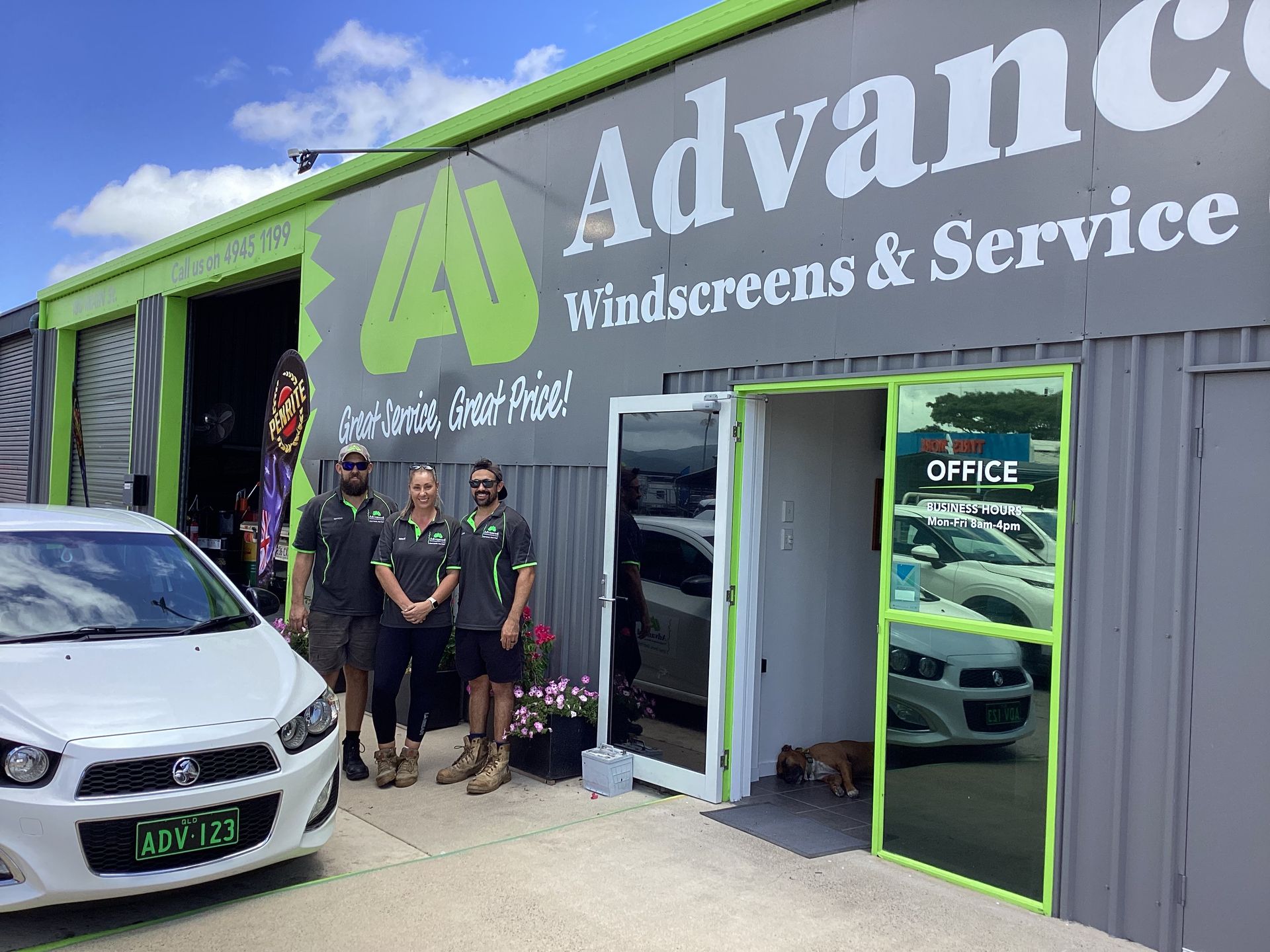 Three People Standing In Front Of A Garage— Advanced Windscreens & Service Centre In Cannonvale, QLD