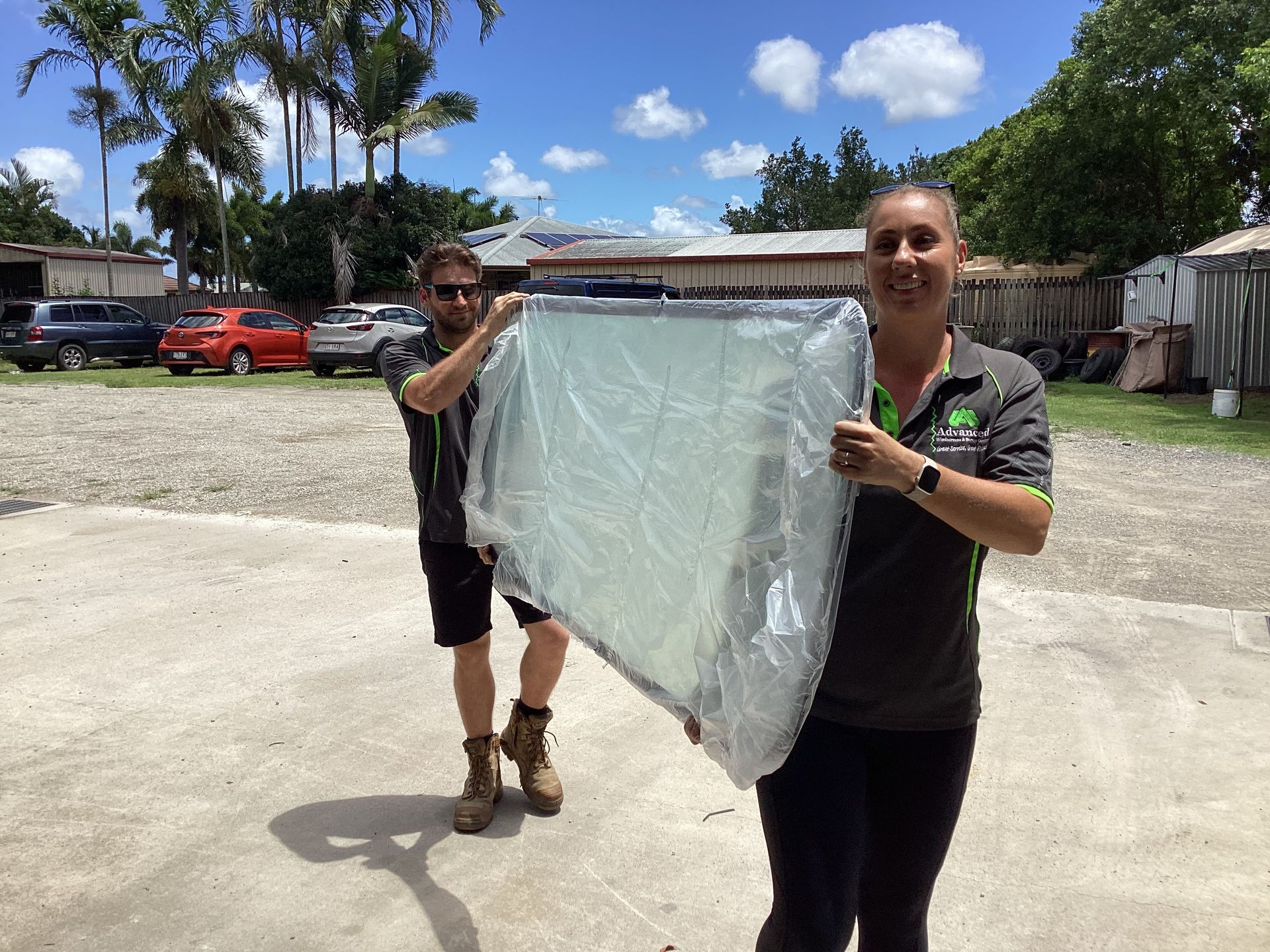 A Man Is Working On The Roof Of A Bus In A Garage — Advanced Windscreens & Service Centre In Bowen, QLD