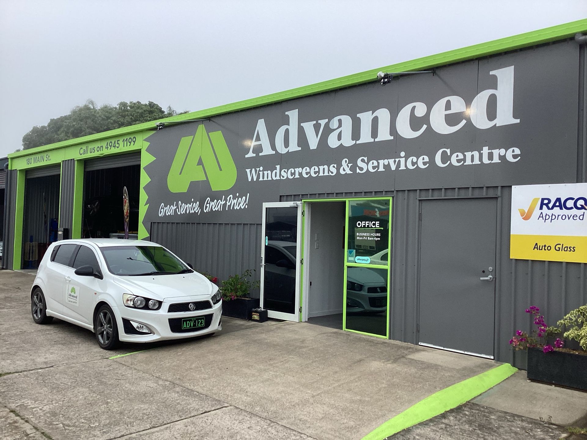 A white car is parked in front of a advanced windscreens and service centre — Advanced Windscreens & Service Centre In Proserpine, QLD