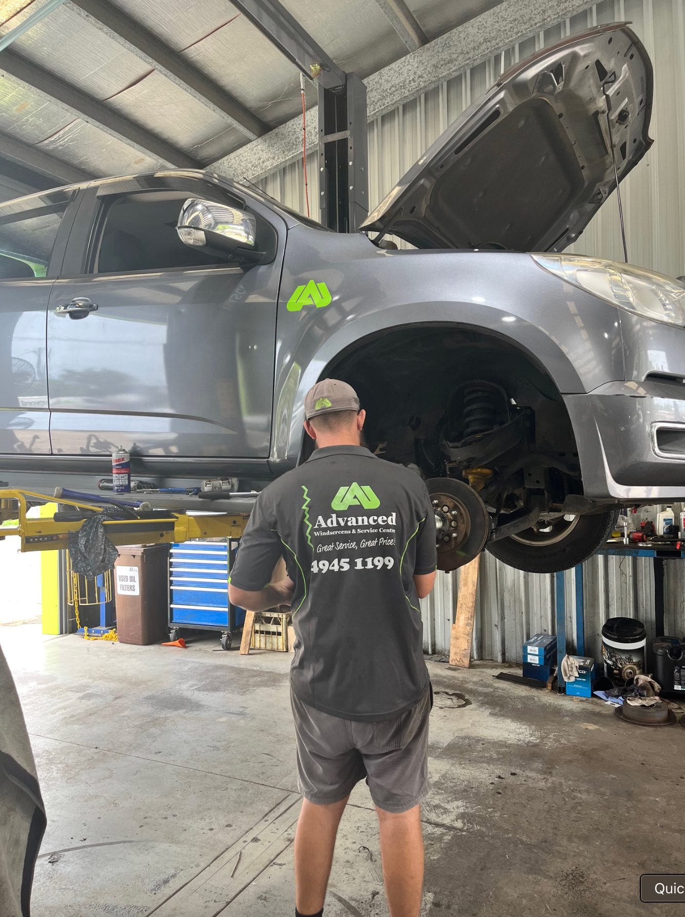 A Mechanic Is Checking The Oil Level Of A Car With A Dipstick — Advanced Windscreens & Service Centre In Proserpine, QLD