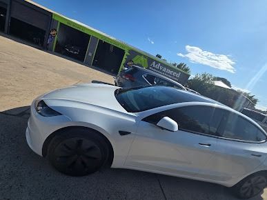 A White Tesla Model 3 Is Parked In Front Of A Building — Advanced Windscreens & Service Centre In Bowen, QLD