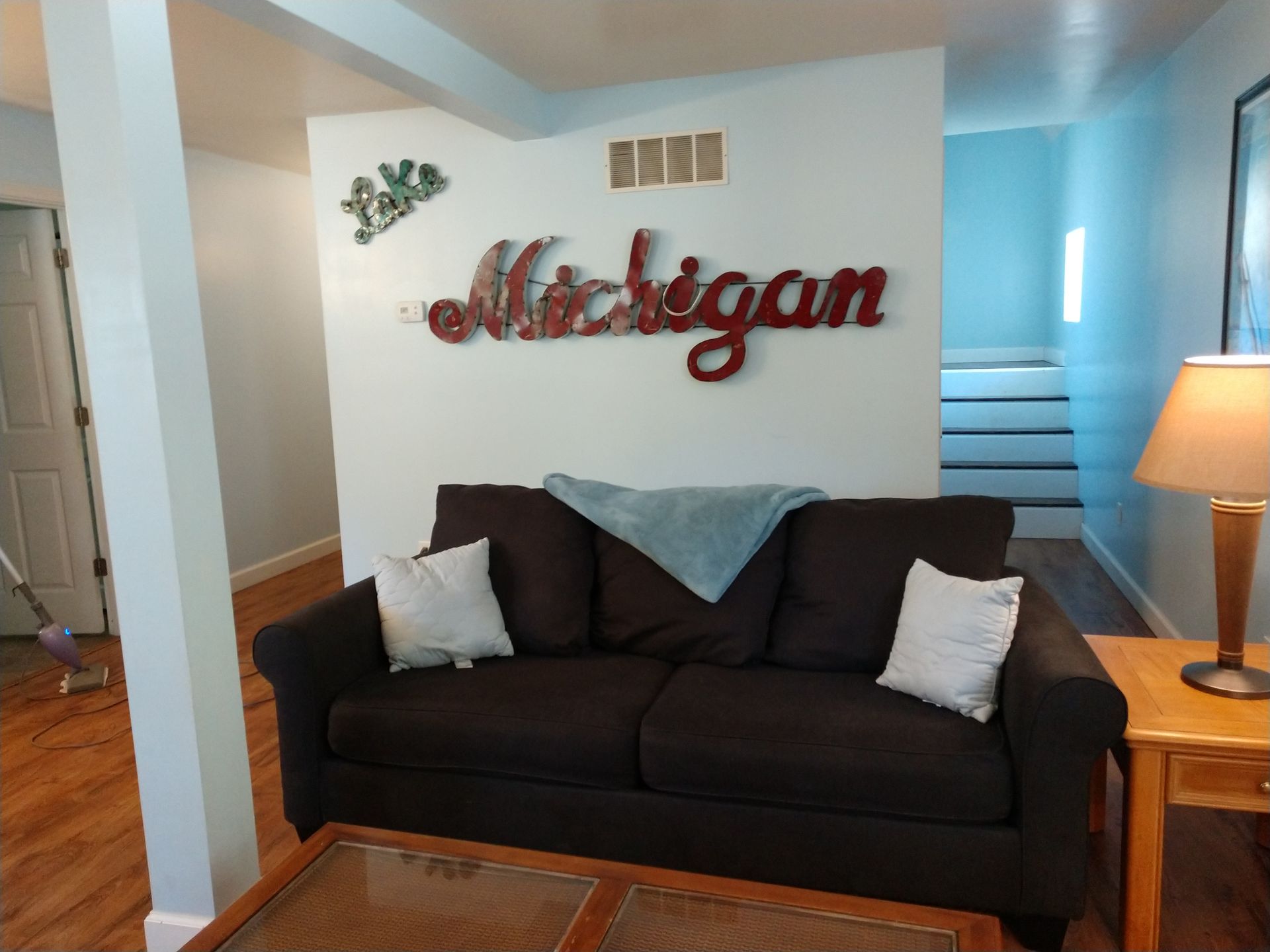 Living room of Duplex East with couch and Lake Michigan sign.