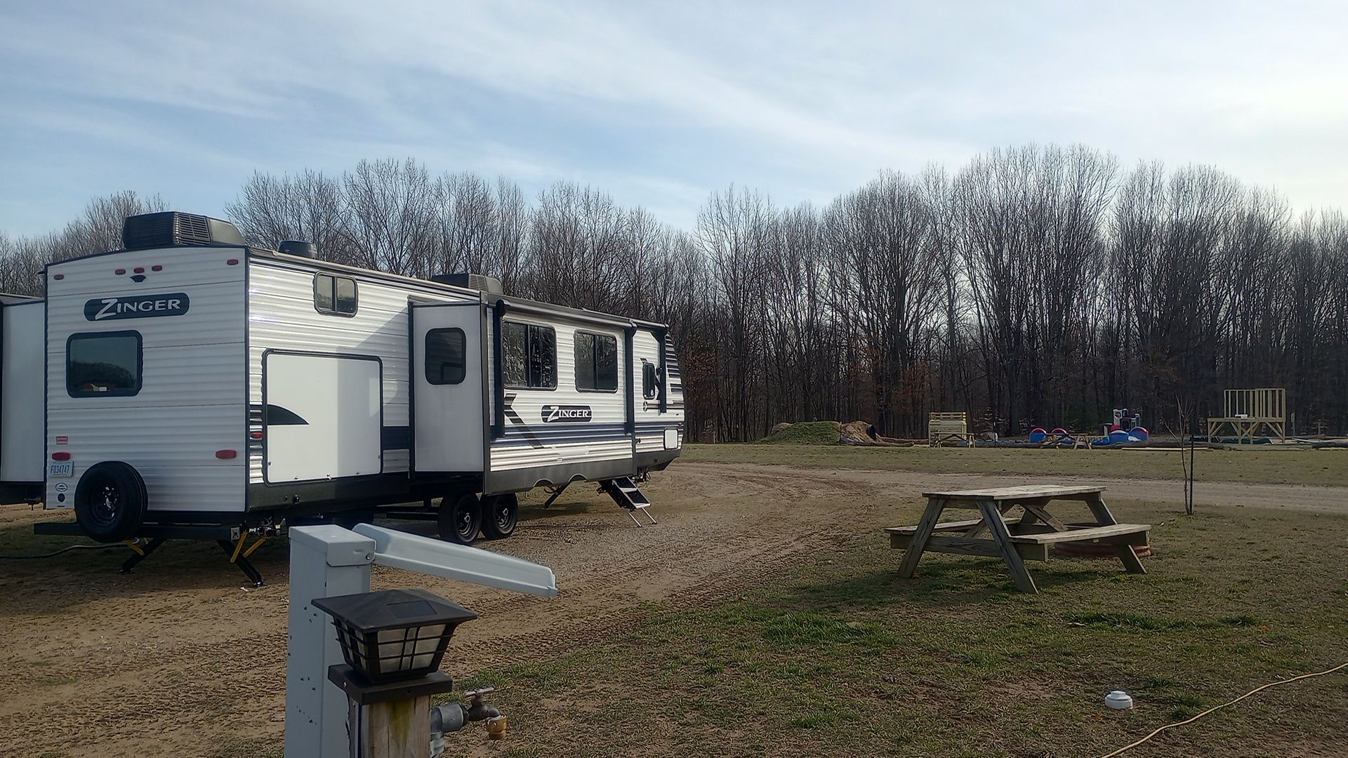 Looking out across the Bunkhouse camper's site with fire ring and picnic table.