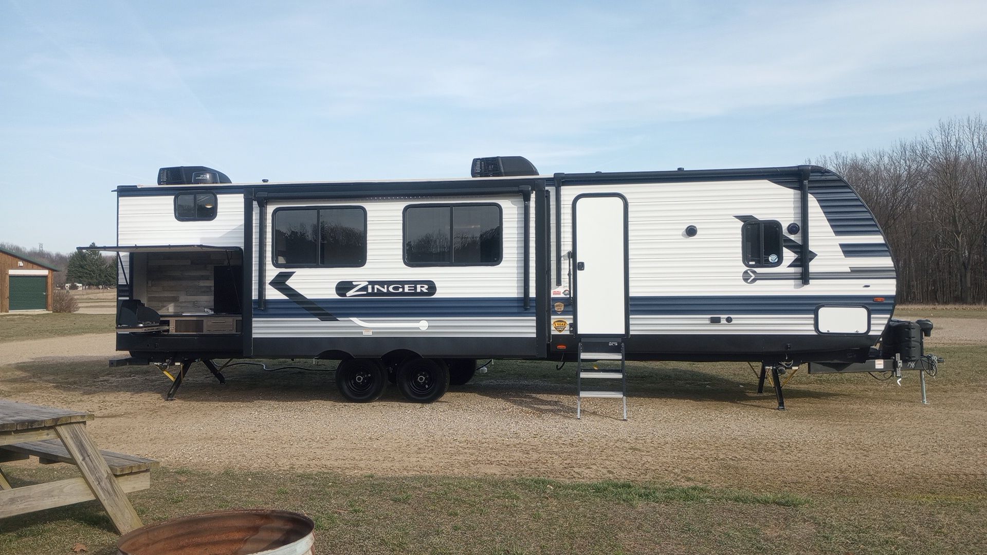 Side view of our 38ft  Bunkhouse camper featuring outdoor kitchen and two slides.