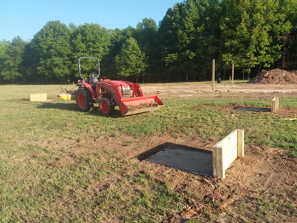 Building horseshoes pits with tractor.