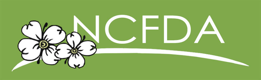 The NCFDA logo, featuring white dogwood flowers over a sweeping white line against a solid olive-green background.