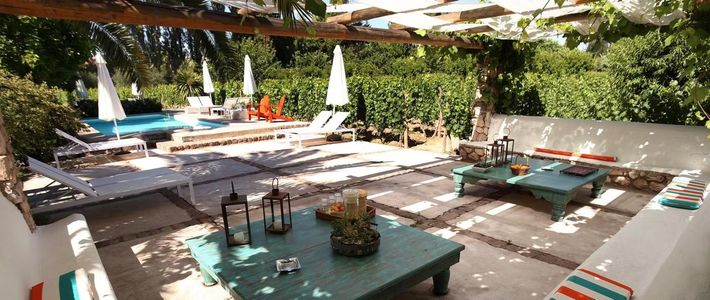Outdoor patio with a pool, seating areas, and a pergola-covered dining space.