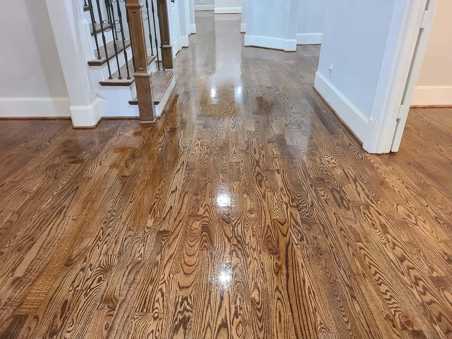 A hallway with hardwood floors and stairs in a house.