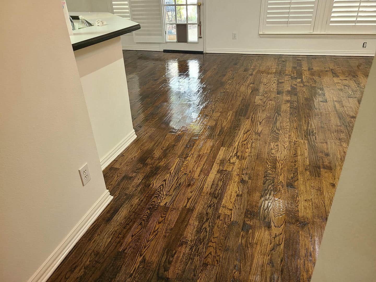 A living room with a wooden floor and white walls.