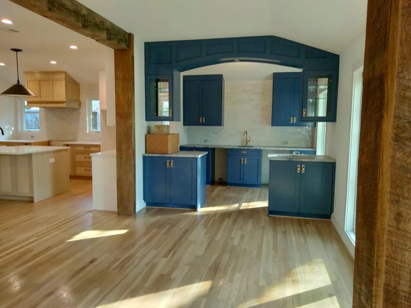 A kitchen with blue cabinets and wooden floors