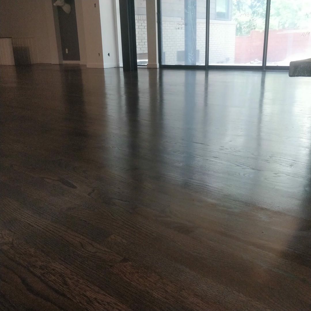 A wooden floor in a living room with a sliding glass door.
