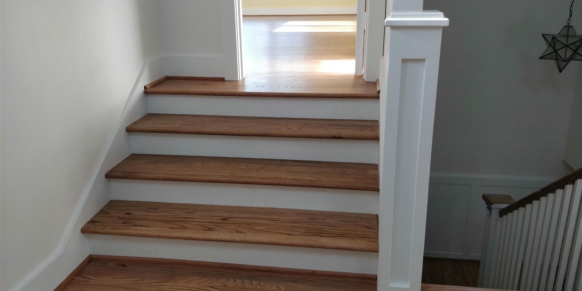 A staircase with wooden steps and a white railing in a house.