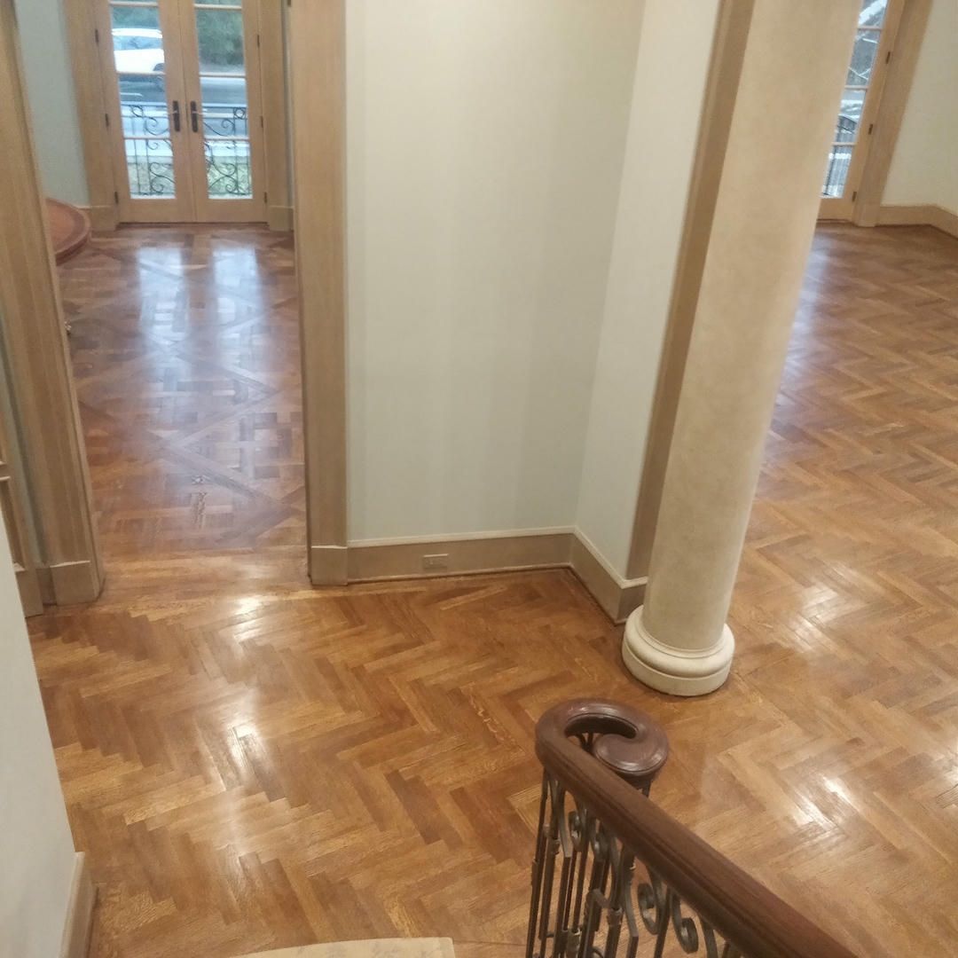 A hallway with a wooden floor and a staircase