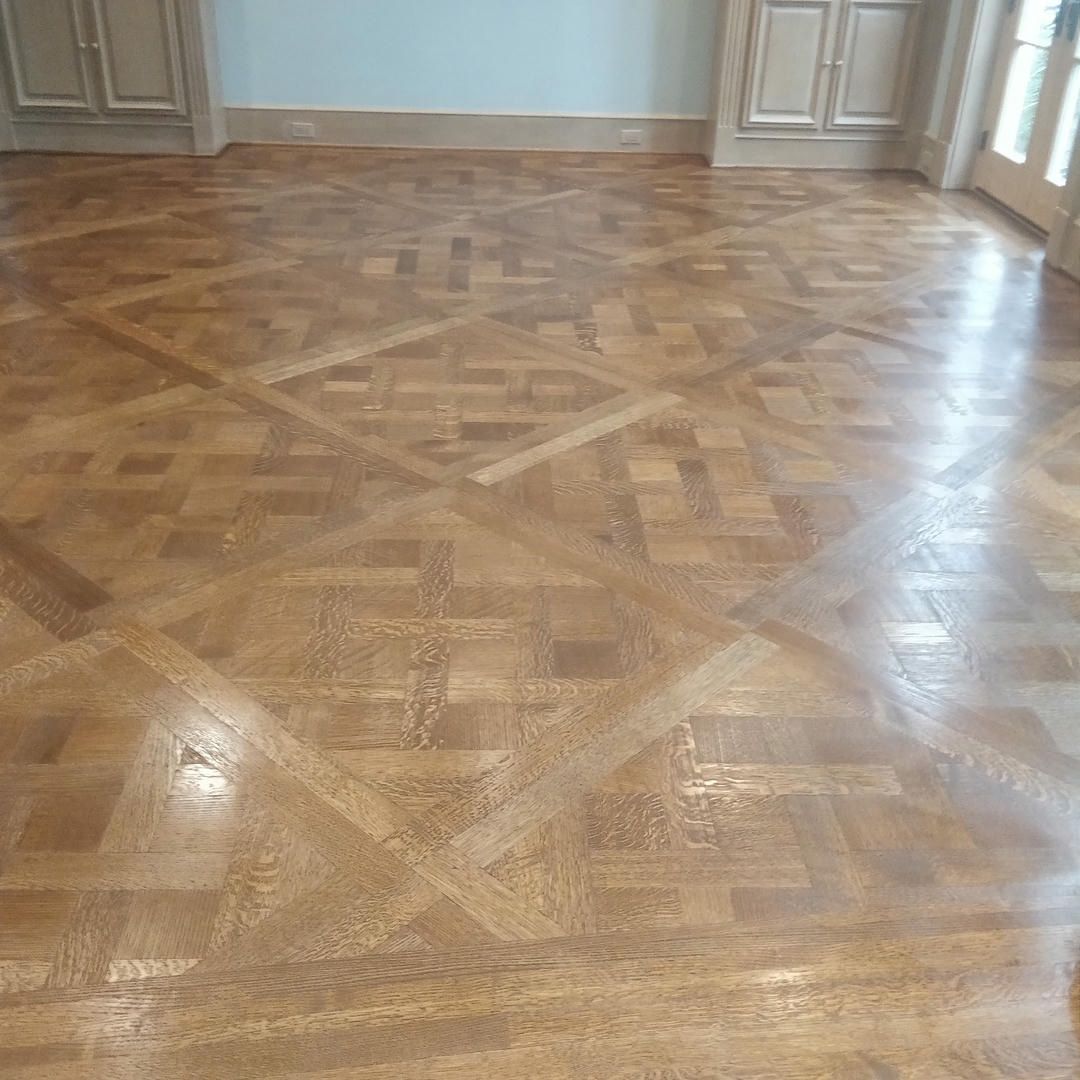 A wooden floor with a pattern on it in a room.