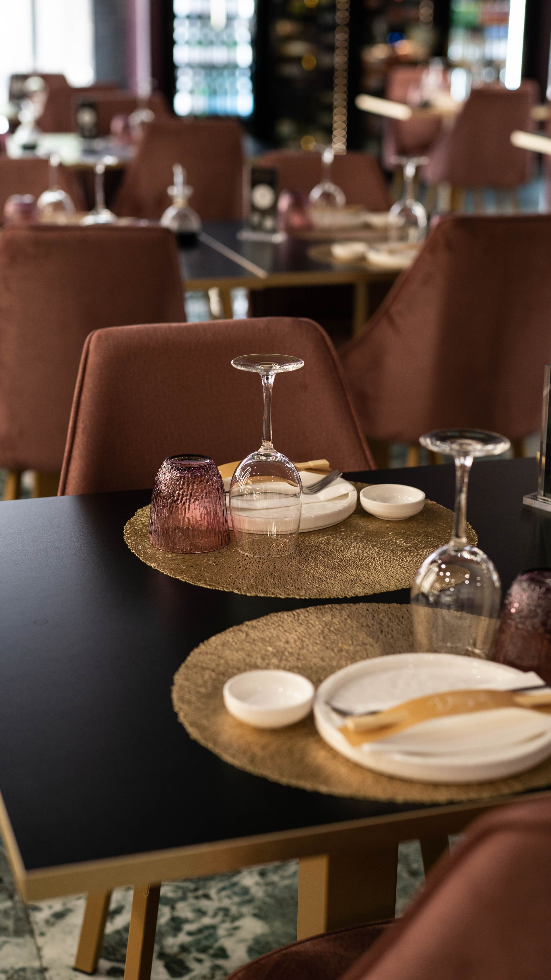 Un ristorante pieno di tavoli e sedie con piatti e bicchieri sopra.