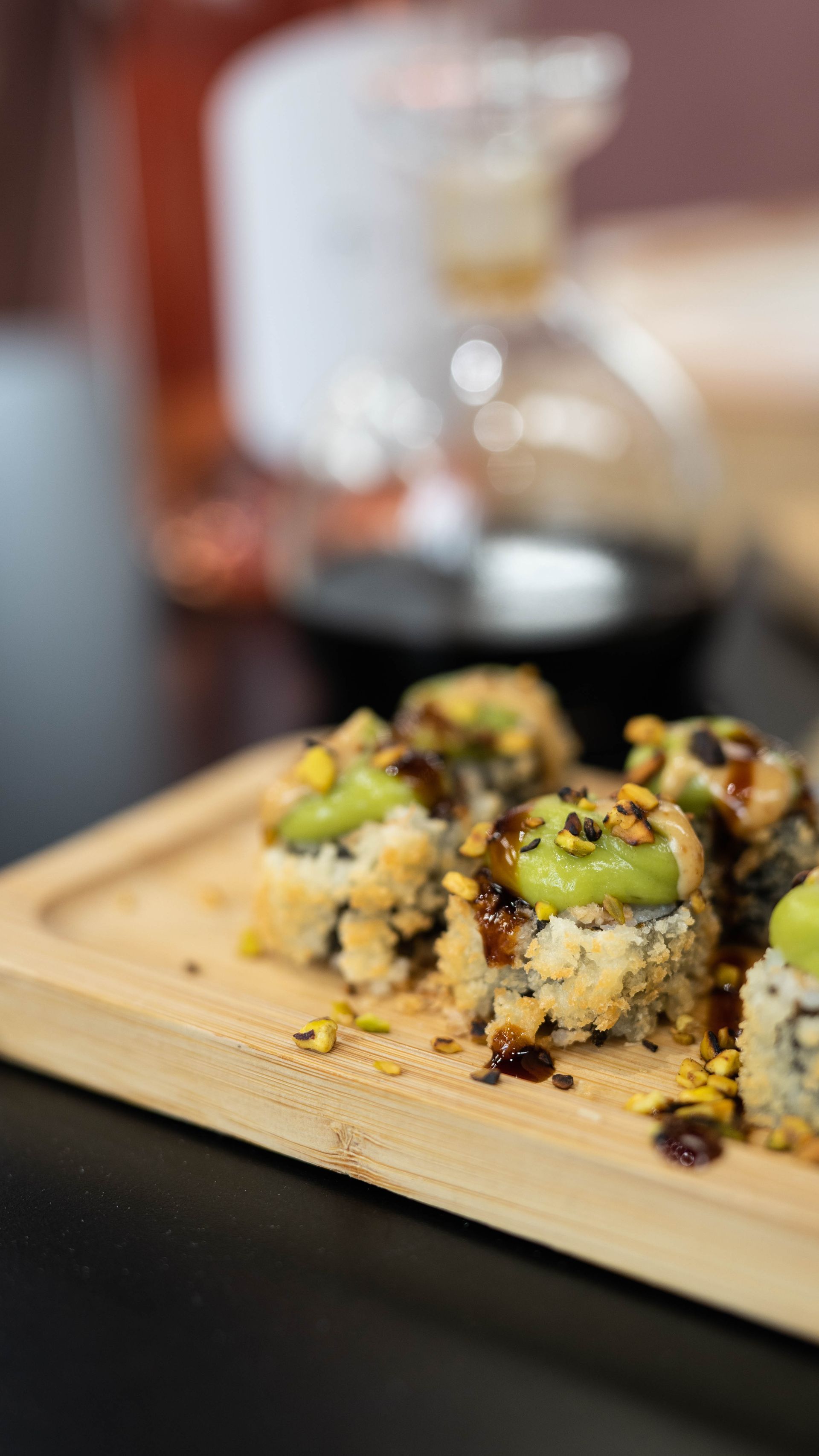 Un primo piano di sushi su un tagliere di legno su un tavolo.