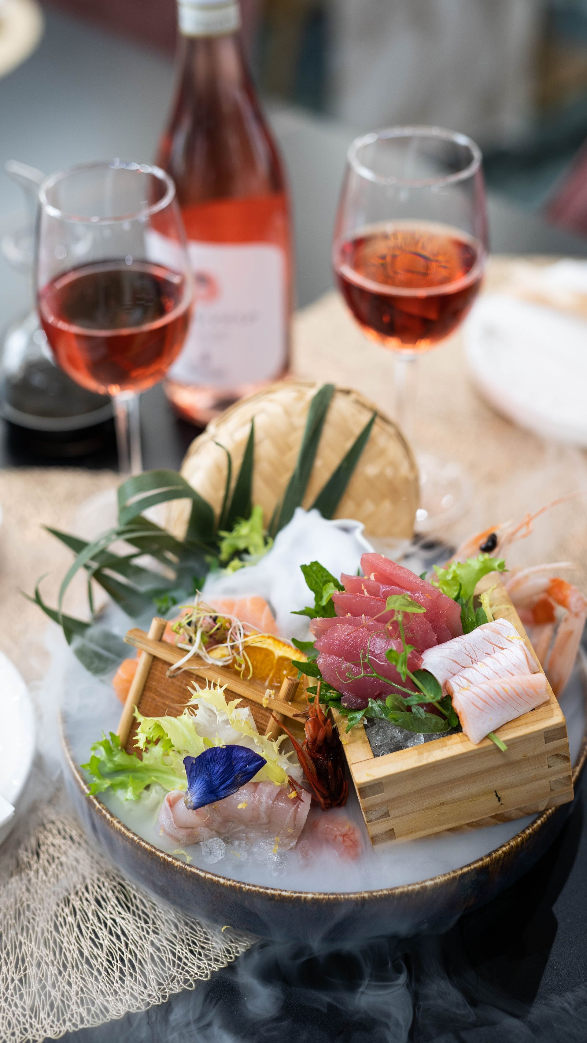 Un piatto di cibo e due bicchieri di vino su un tavolo.