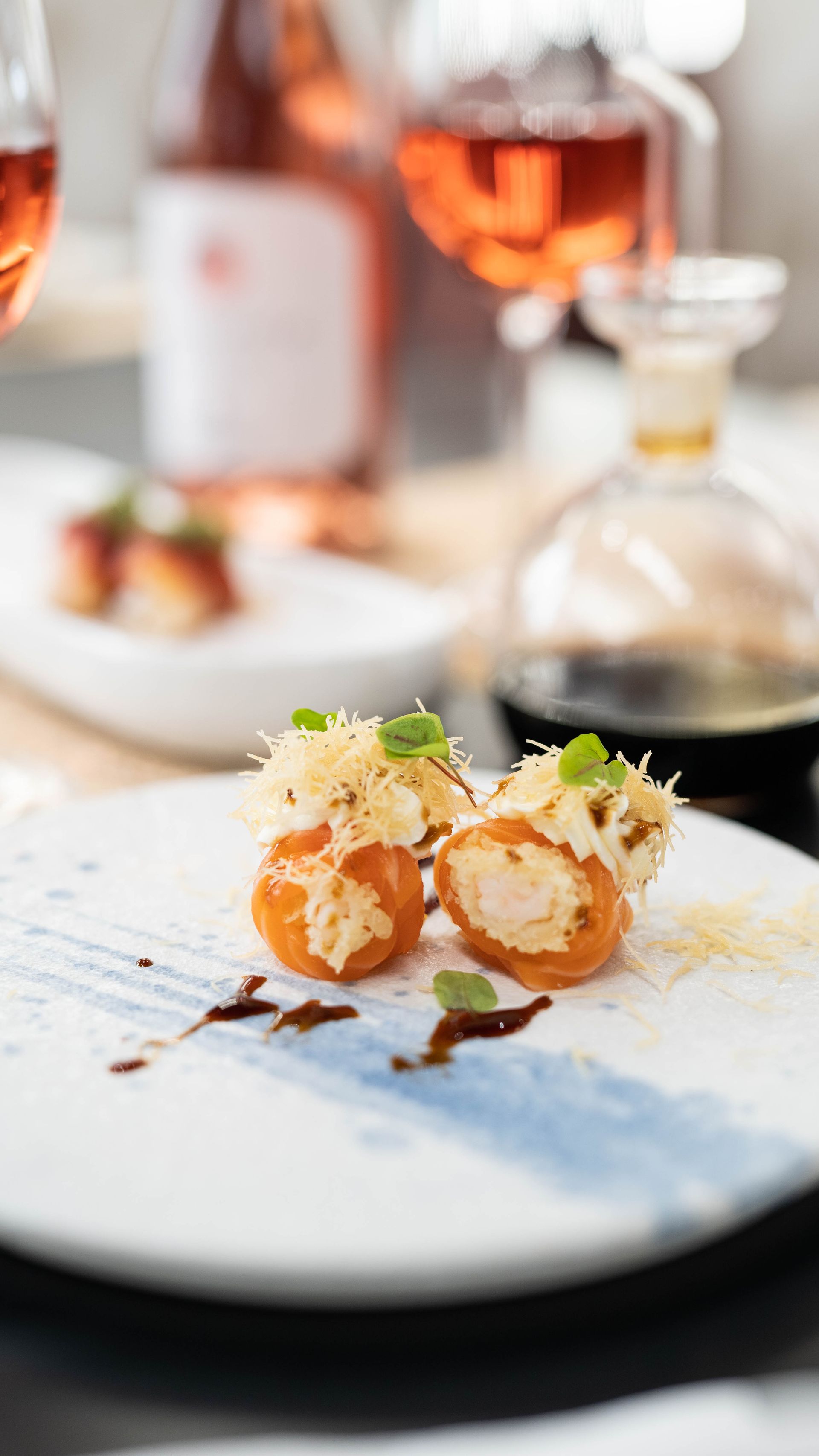 Un primo piano di un piatto di cibo con una bottiglia di vino sullo sfondo.