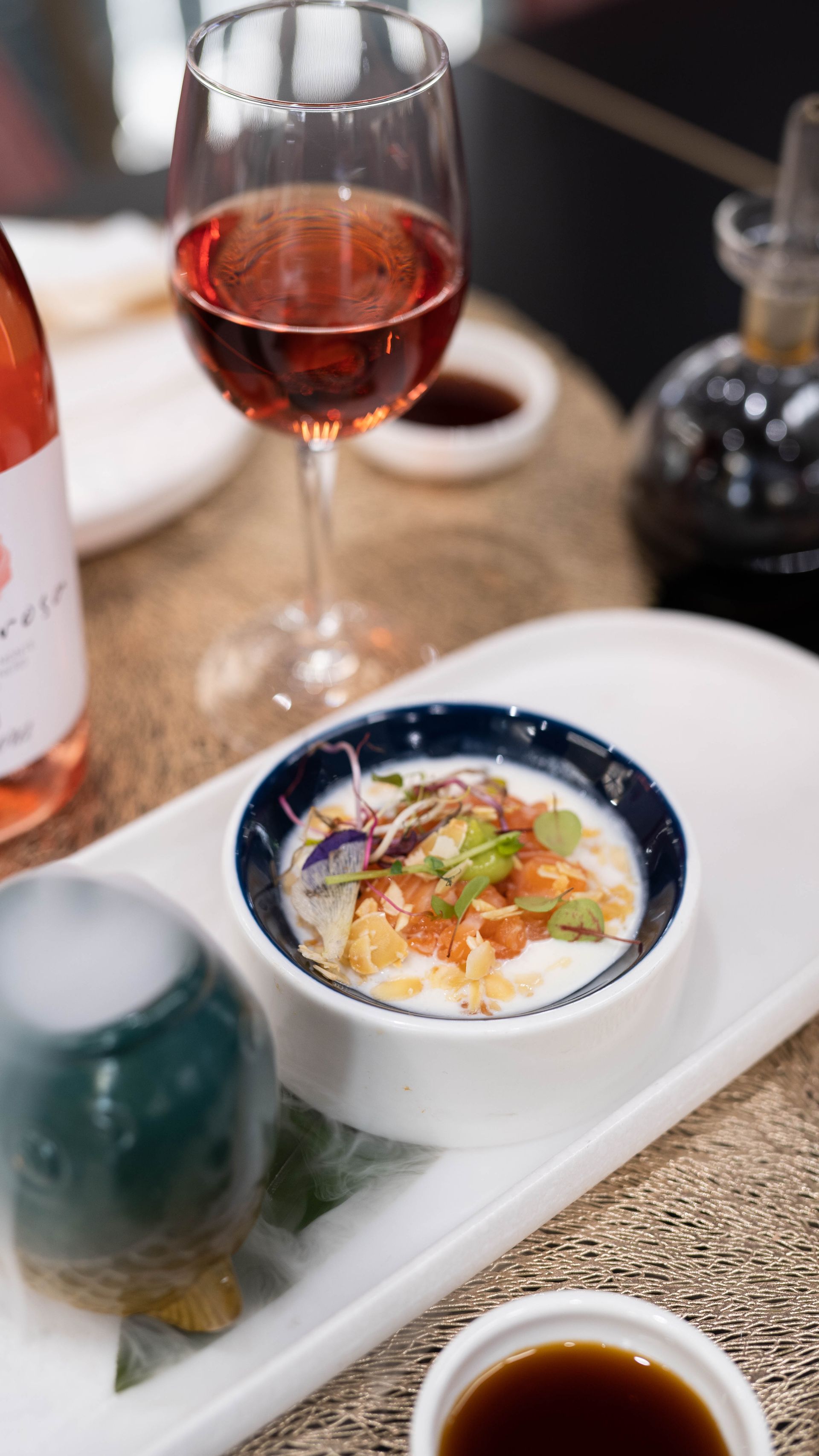 Un piatto di cibo e un bicchiere di vino su un tavolo.