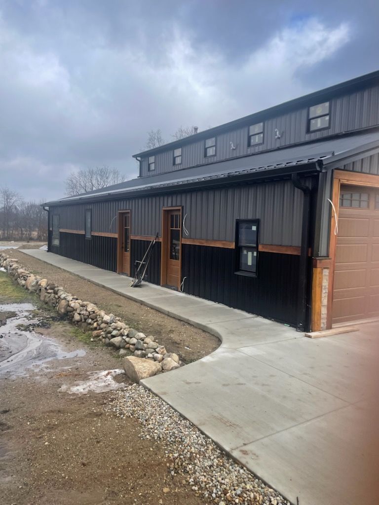 White gutters and downspout on a brick building with a red tile roof.