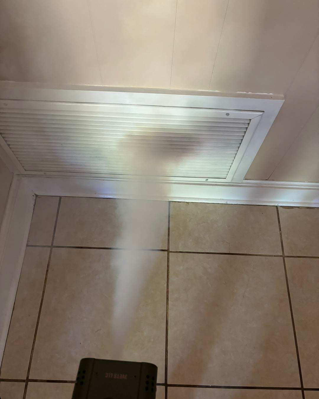 A fan is blowing air through a vent on the ceiling.