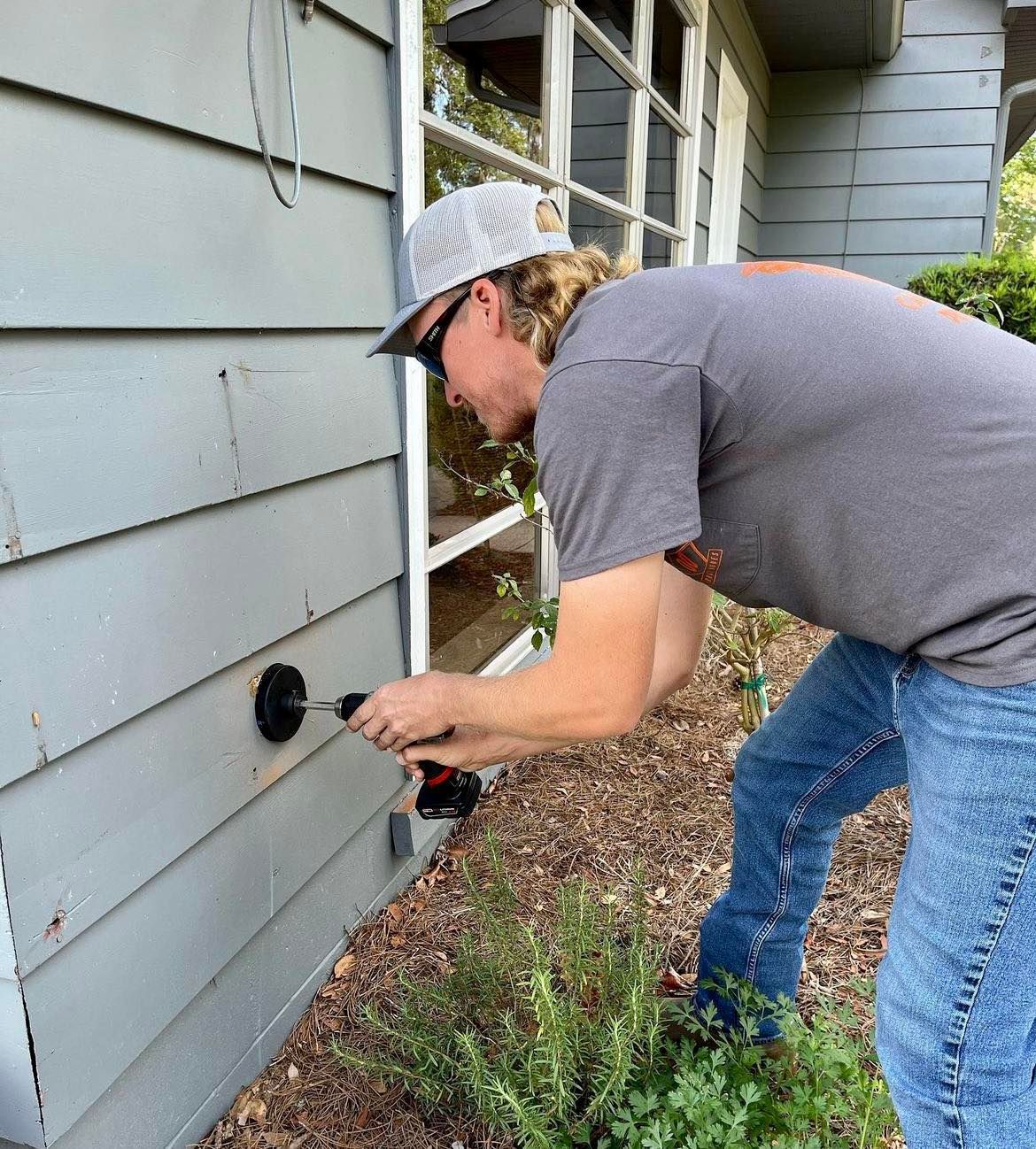 A man is working on the side of a house.
