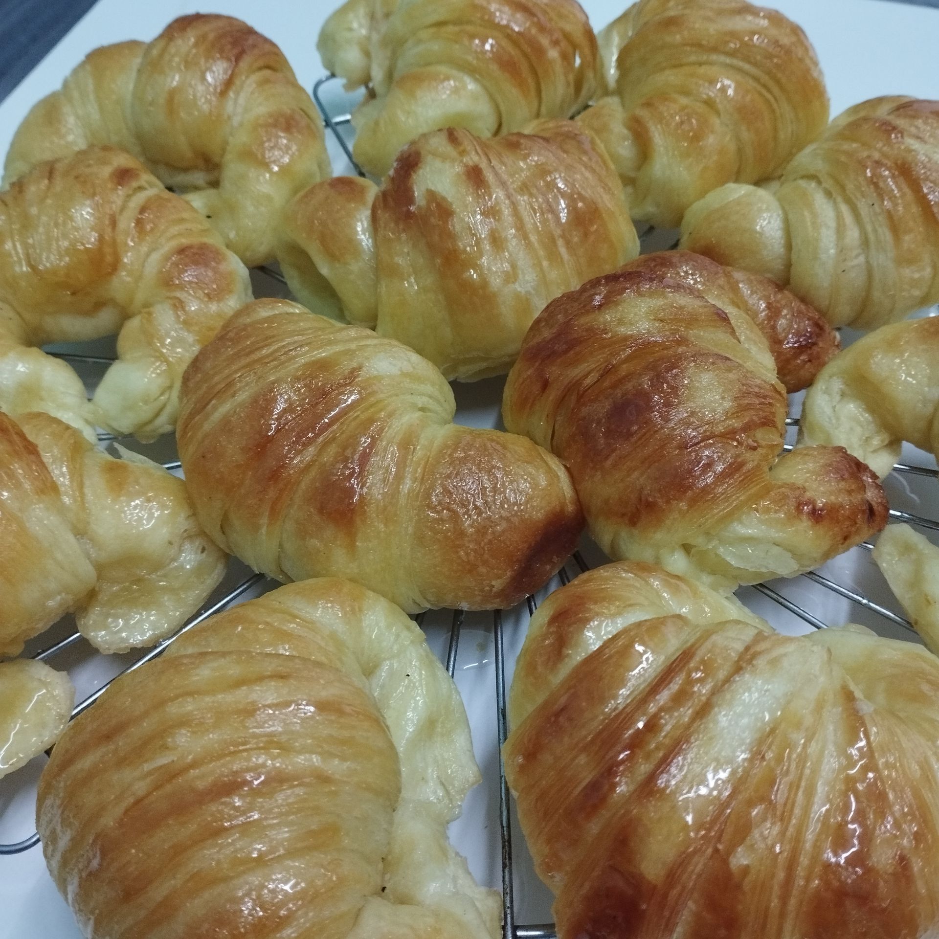Croissants rellenos de crema y caramelo en una bandeja blanca.