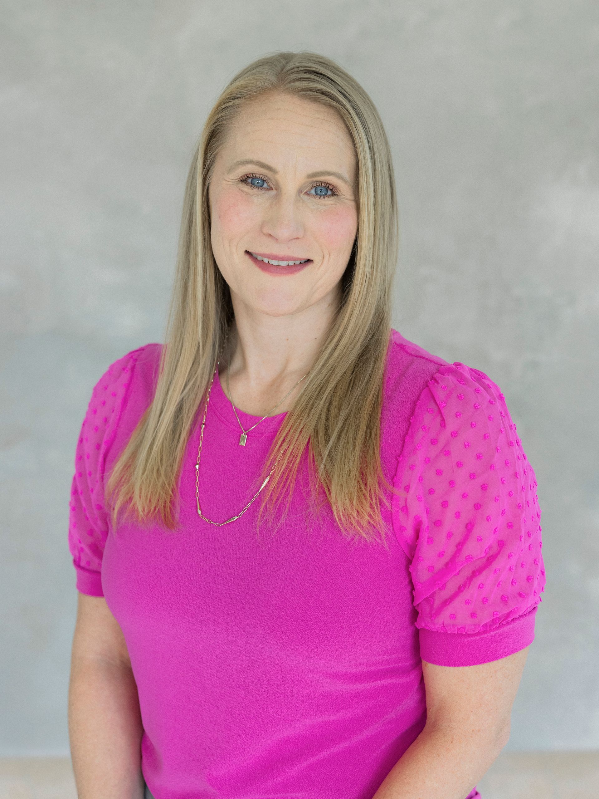 A man in a suit and white shirt is smiling for the camera.