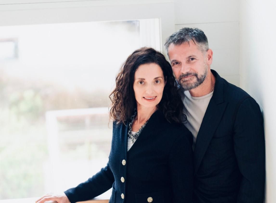 A man in a suit and blue shirt smiles for the camera
