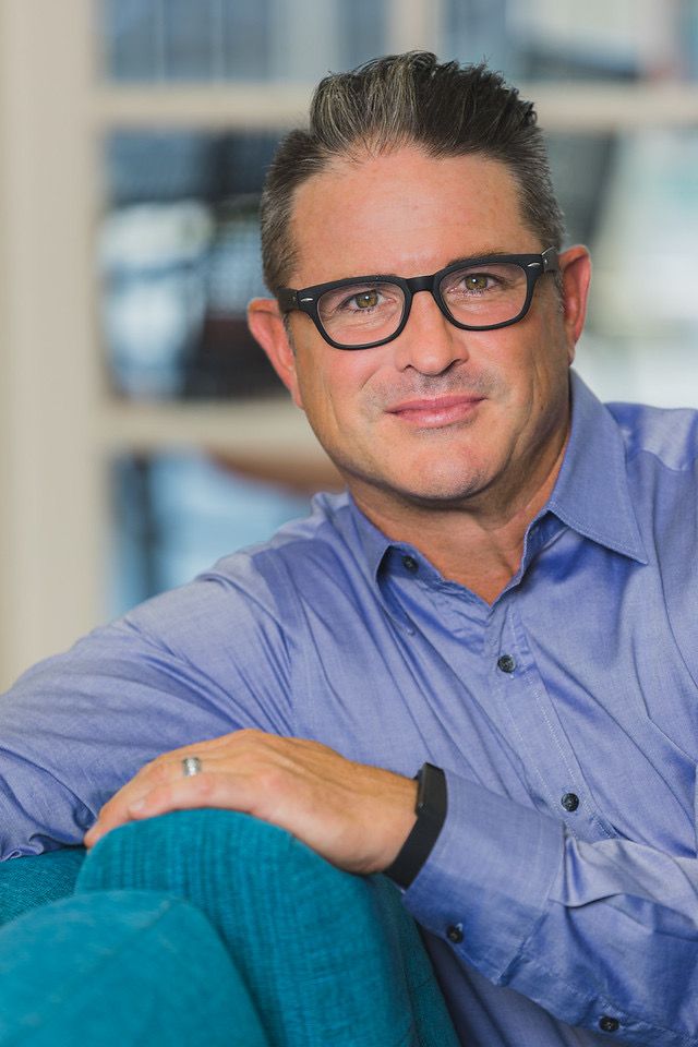 A bald man with a beard and mustache is smiling for the camera.