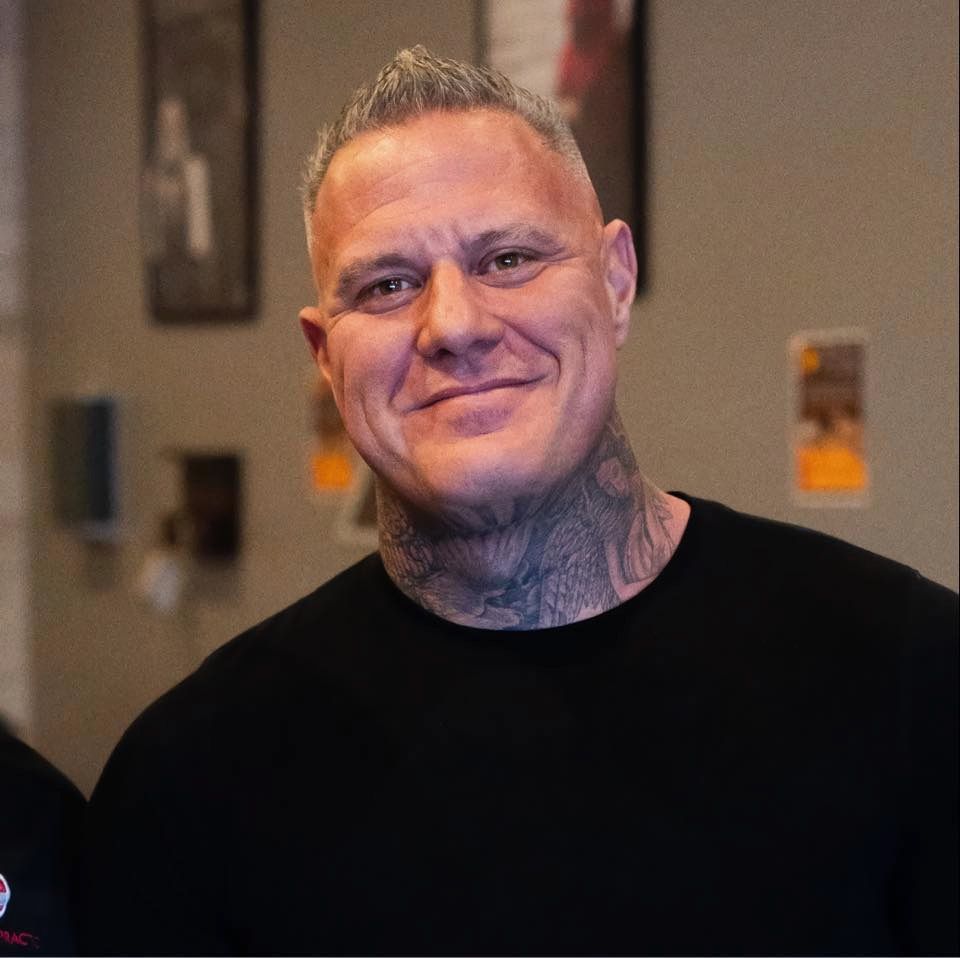 A man is sitting in a chair with his hands folded.