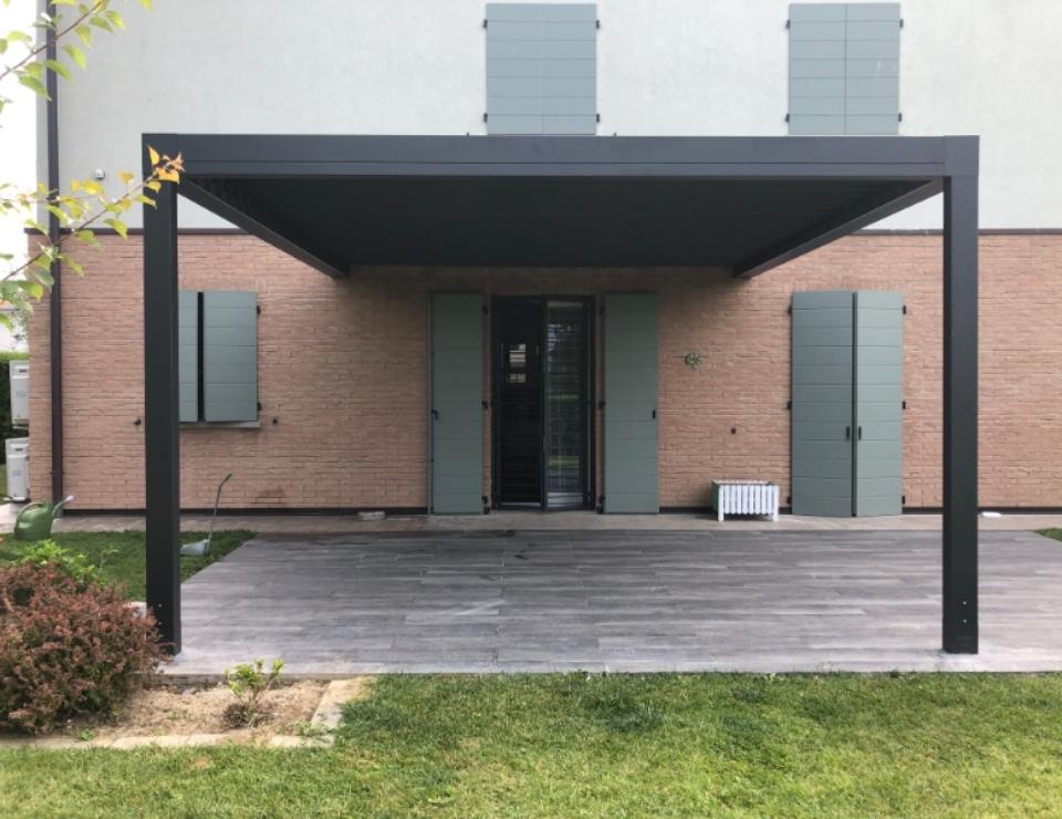 pergola bioclimatica nera in giardino pavimentato