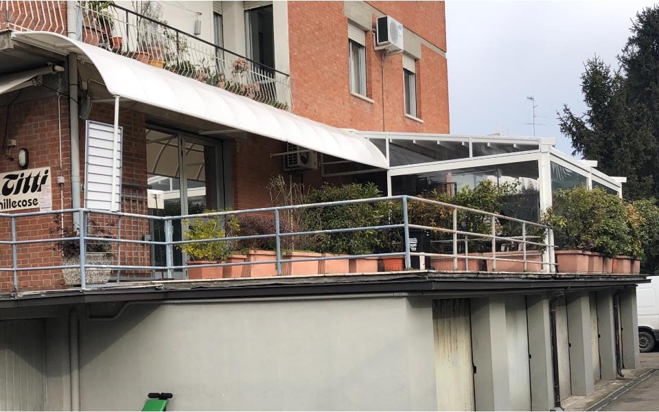 pergola bioclimatica e tenda curva fuori da un'attività commerciale