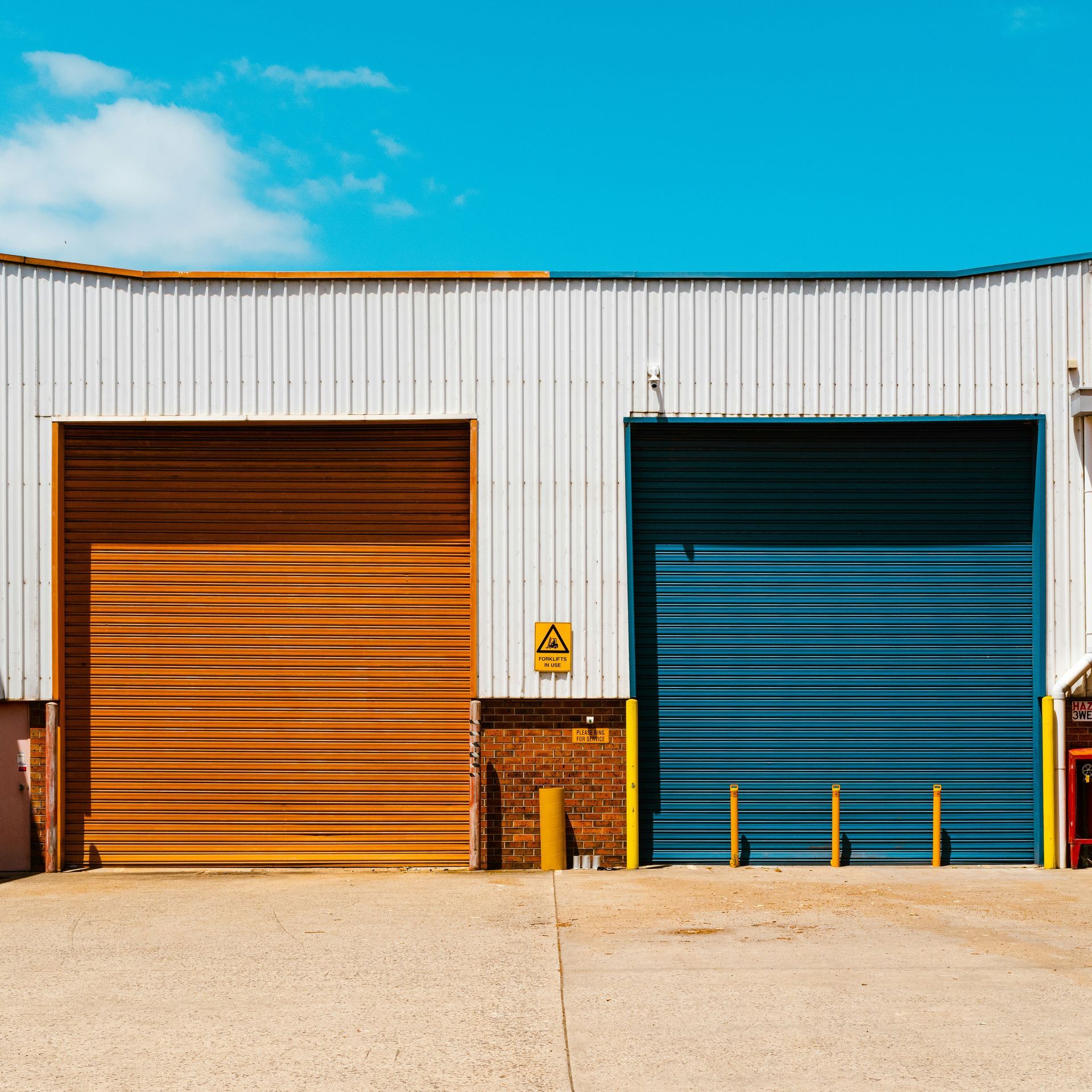 There are two garage doors on the side of a building.